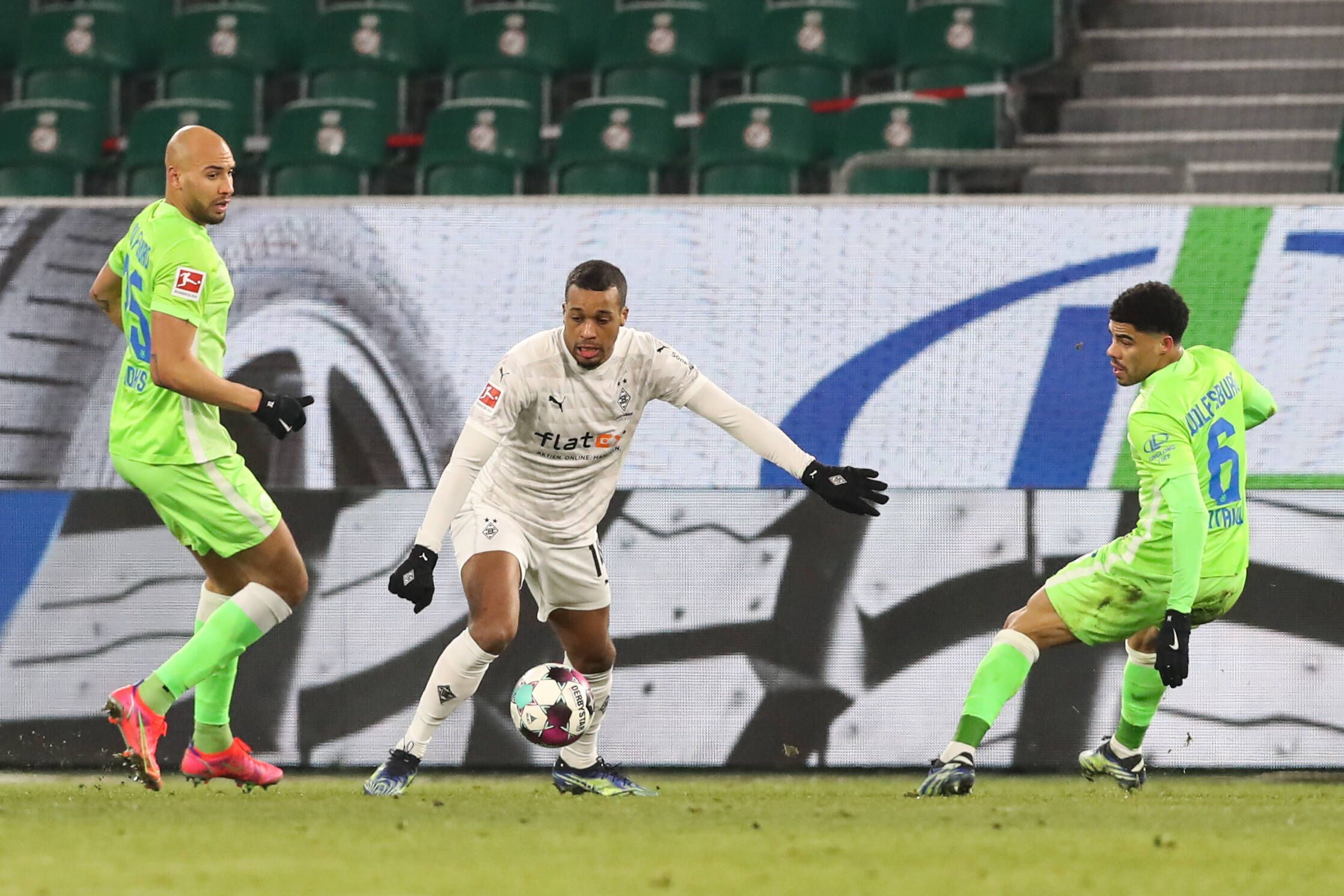 Alassane Plea (Borussia Mönchengladbach,14) im Zweikampf mit John Anthony Brooks und Paulo Otavio (VfL Wolfsburg) am 14. Februar 2021 in der Volkswagen-Arena.