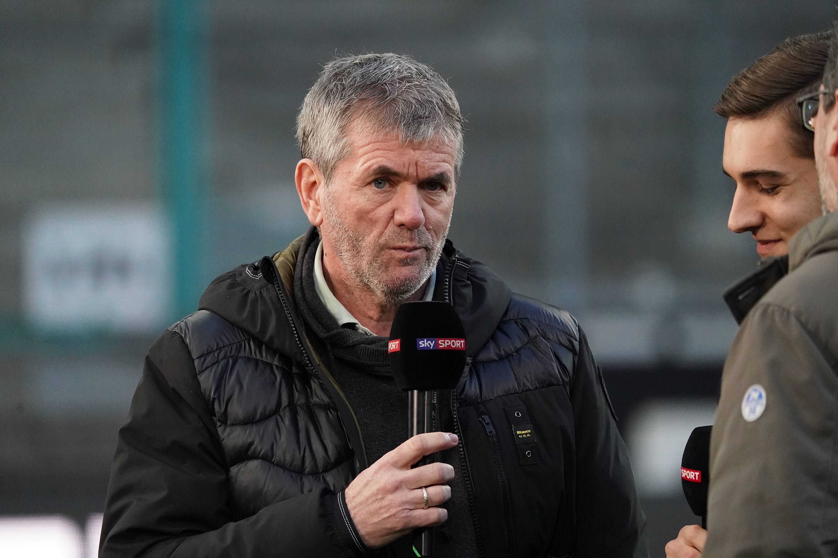 Trainer-Ikone Friedhelm Funkel (l.), hier bei einem TV-Interview am 11. März 2020 im Borussia-Park zu sehen, spricht und schaut in die Kamera.