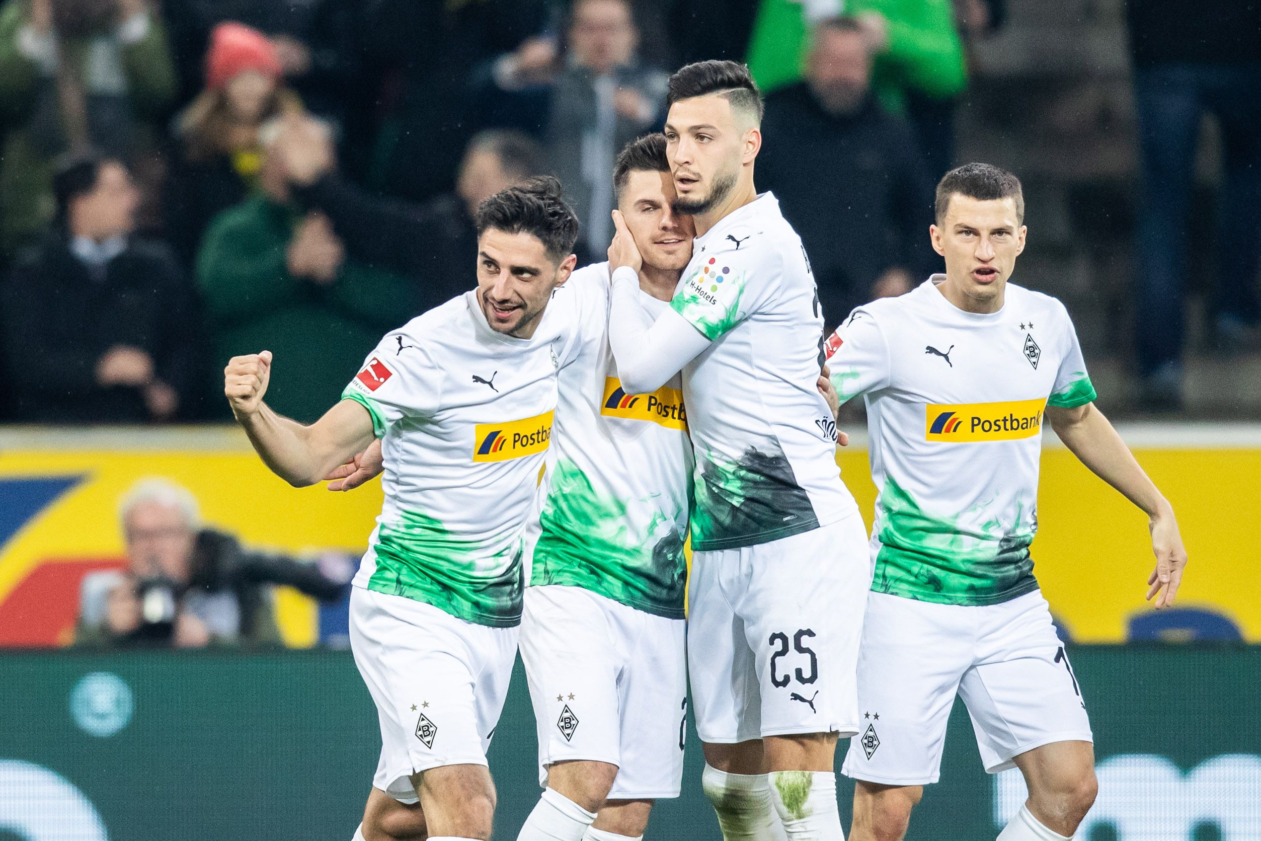 Gladbachs Torschütze zum 1:1, beim Bundesliga-Spiel gegen Borussia Dortmund am 7.3.2020, Lars Stindl (l) wird von Gladbachs Florian Neuhaus (m), Gladbachs Ramy Bensebaini (2.v.r) und Gladbachs Stefan Lainer (r) gefeiert.