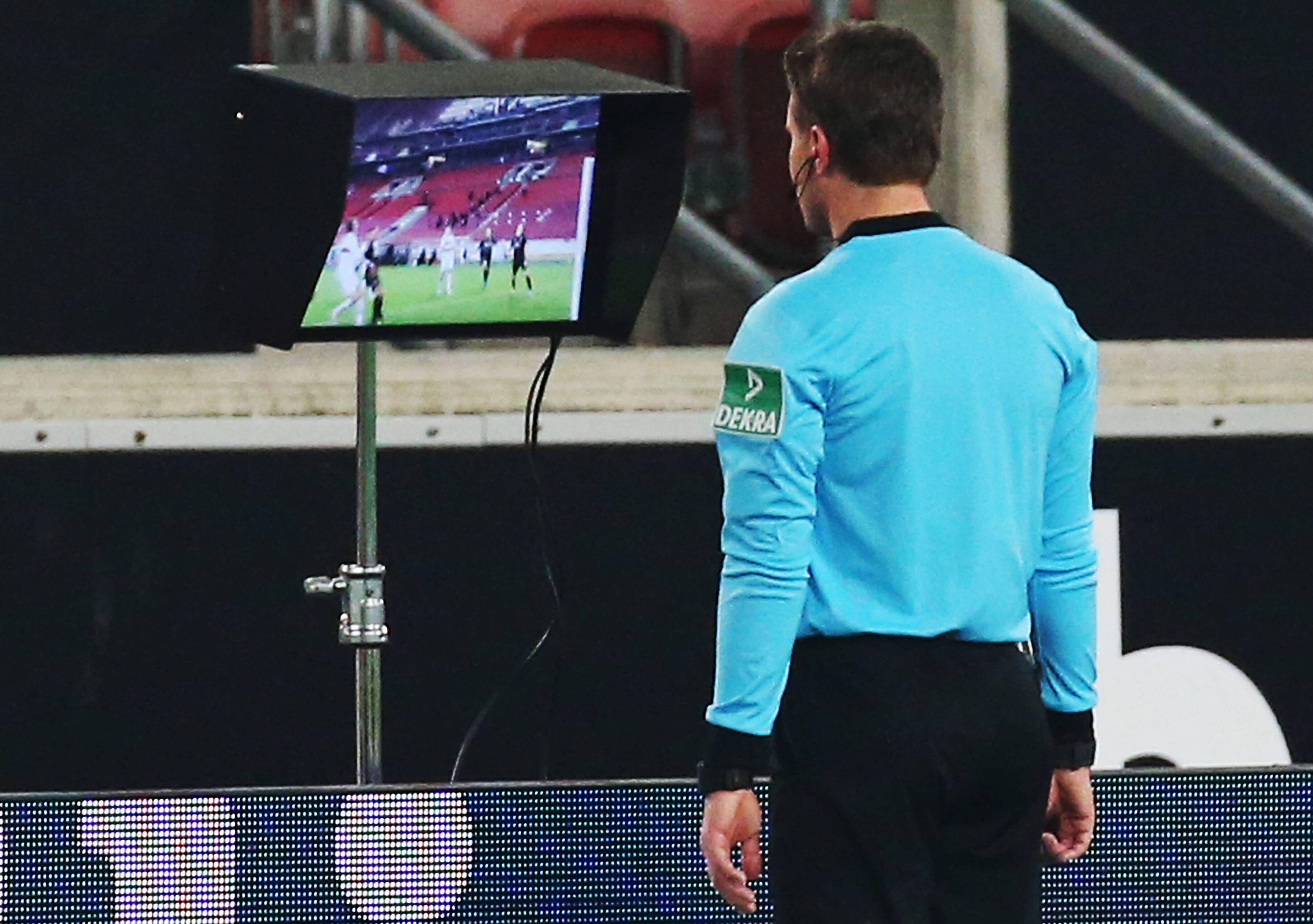 Schiedsrichter Felix Brych schaut sich beim Bundesliga-Duell (16.01.2021) zwischen Stuttgart und Borussia Mönchengladbach in der Nachspielzeit noch einmal auf einem Bildschirm eine strittige Szene an.