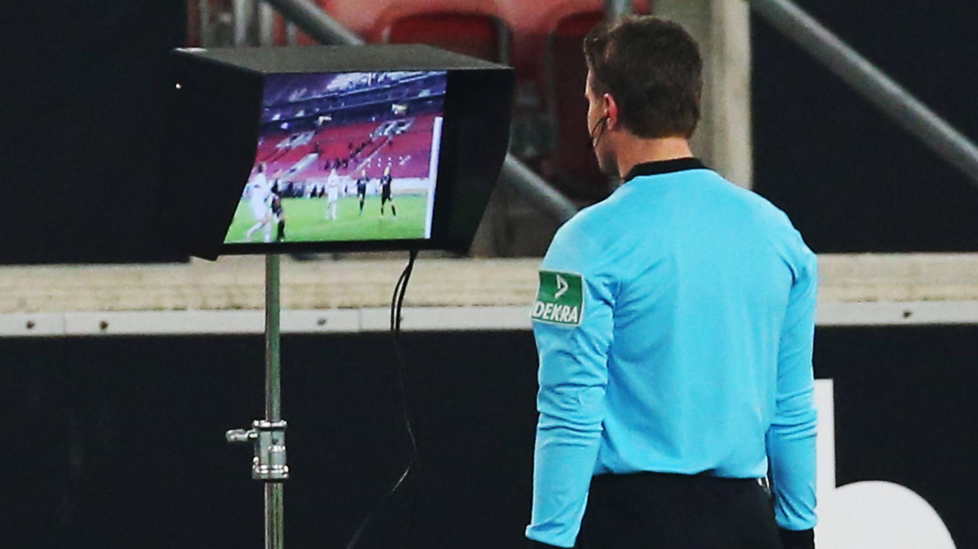 Schiedsrichter Felix Brych schaut sich beim Bundesliga-Duell (16.01.2021) zwischen Stuttgart und Borussia Mönchengladbach in der Nachspielzeit noch einmal auf einem Bildschirm eine strittige Szene an.