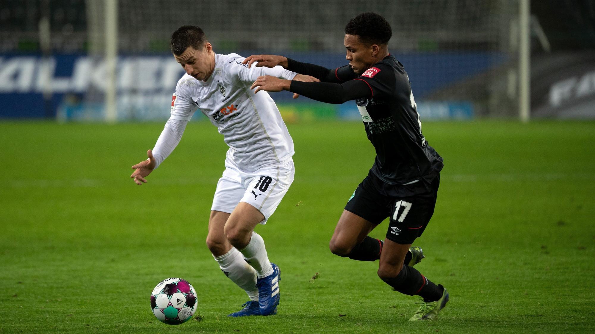 Borussias Rechtsverteidiger Stefan Lainer (l.) wird von Bremens Felix Agu angegangen.