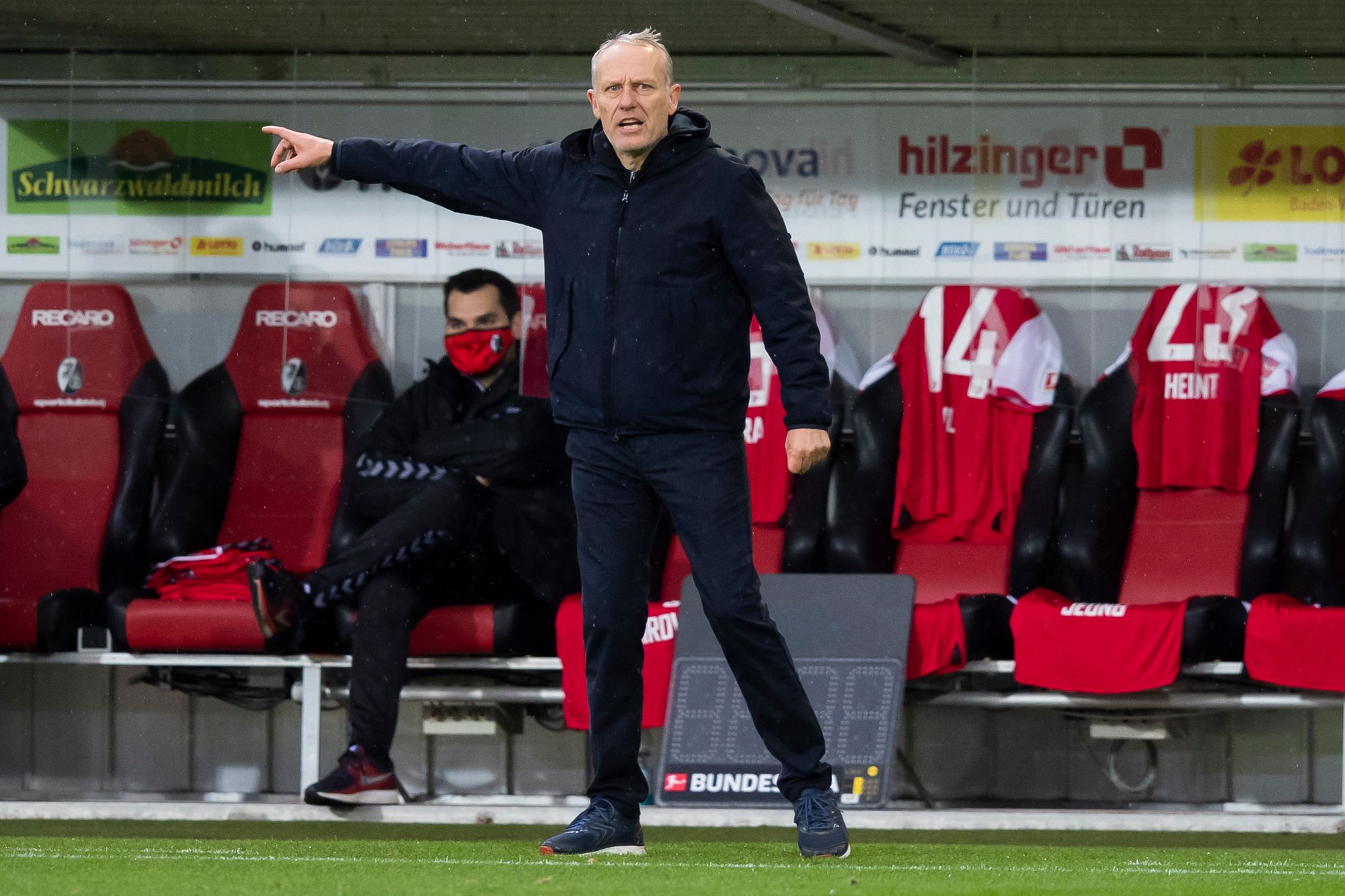 Freiburgs Trainer Christian Streich, hier am 12.12.2020 beim Duell gegen Arminia Bielefeld, zeigt mit der rechten Hand Richtung Spielfeld.