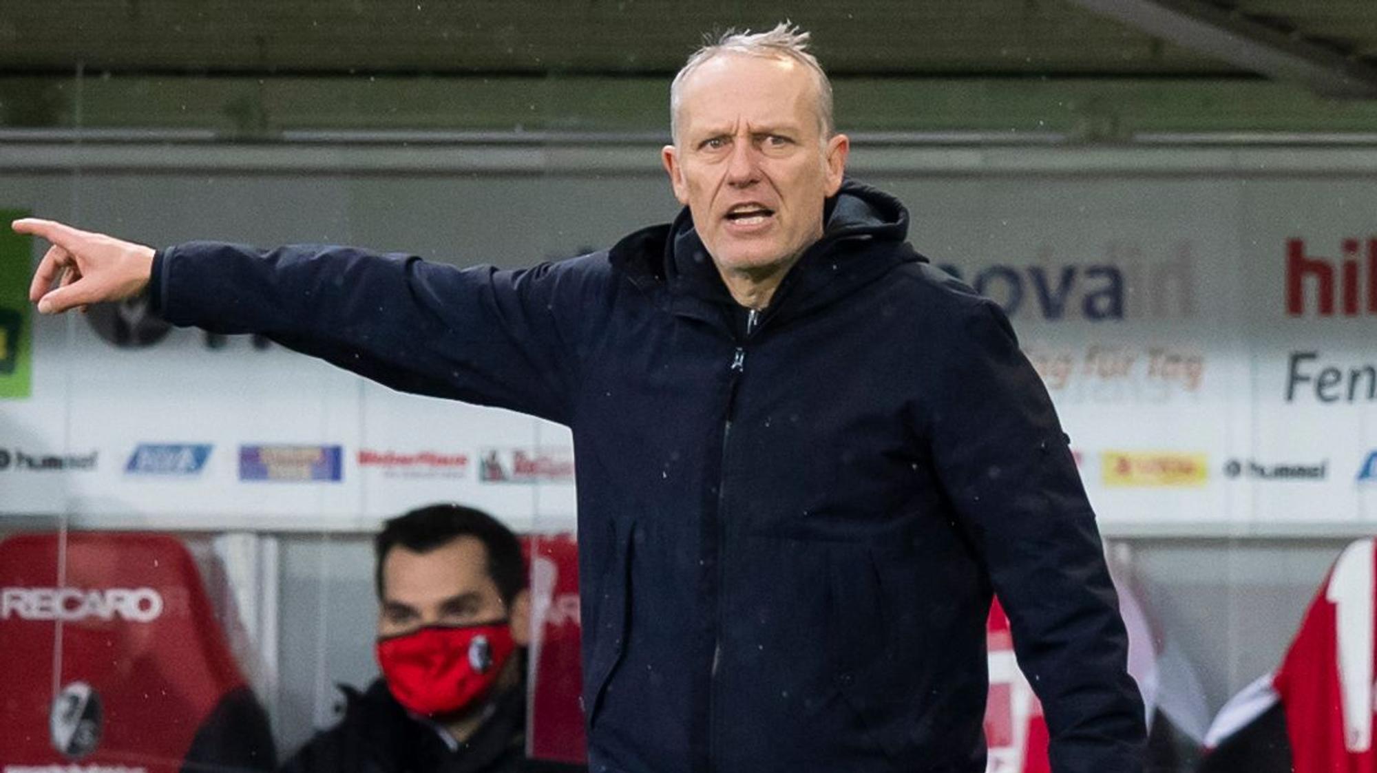Freiburgs Trainer Christian Streich, hier am 12.12.2020 beim Duell gegen Arminia Bielefeld, zeigt mit der rechten Hand Richtung Spielfeld.