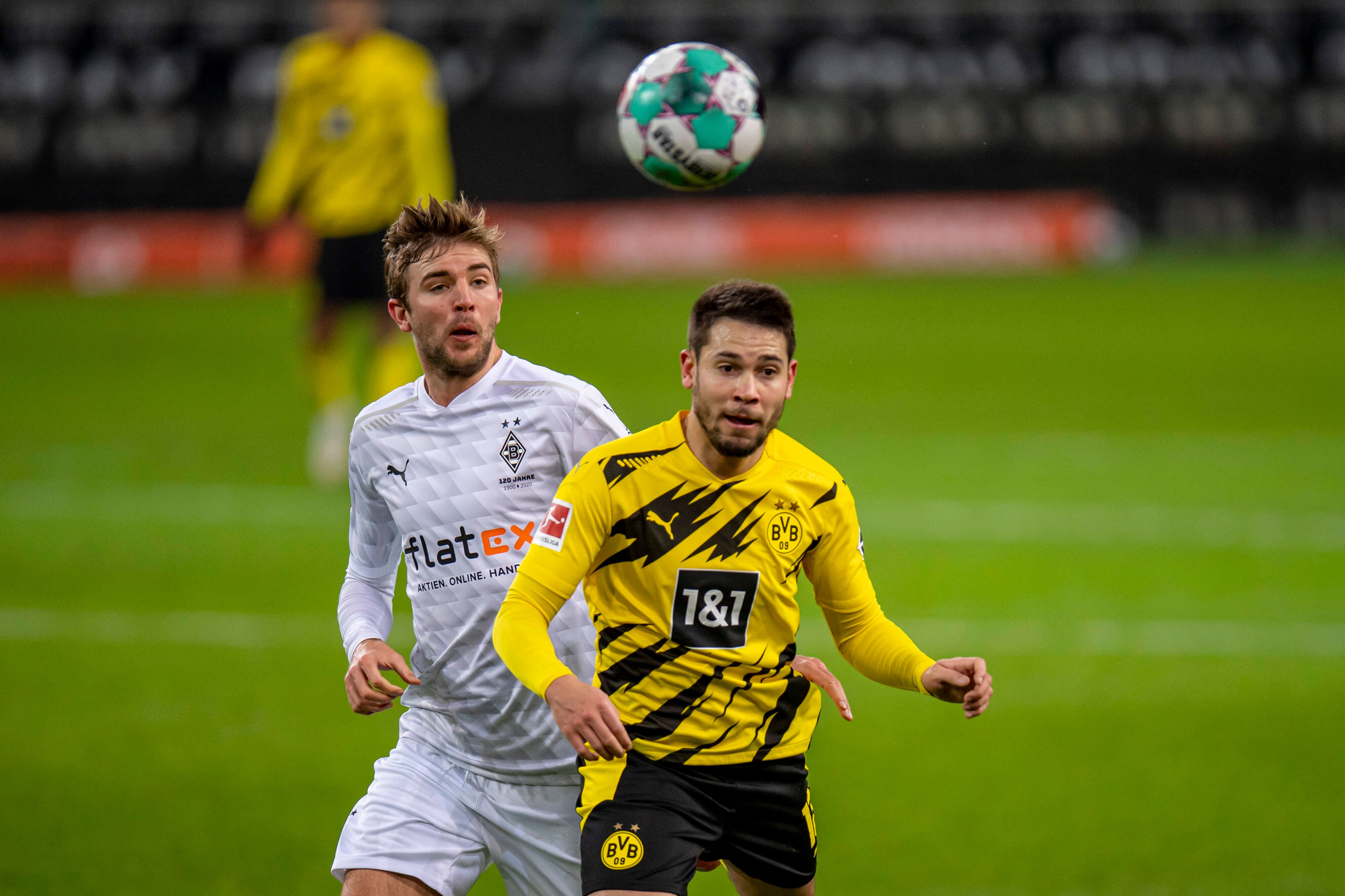 Gladbachs Mittelfeldspieler Christoph Kramer (l.) und Dortmunds Raphael Guerreiro (r.) blicken im Bundesliga-Duell am 22. Januar 2021 auf den Ball.
