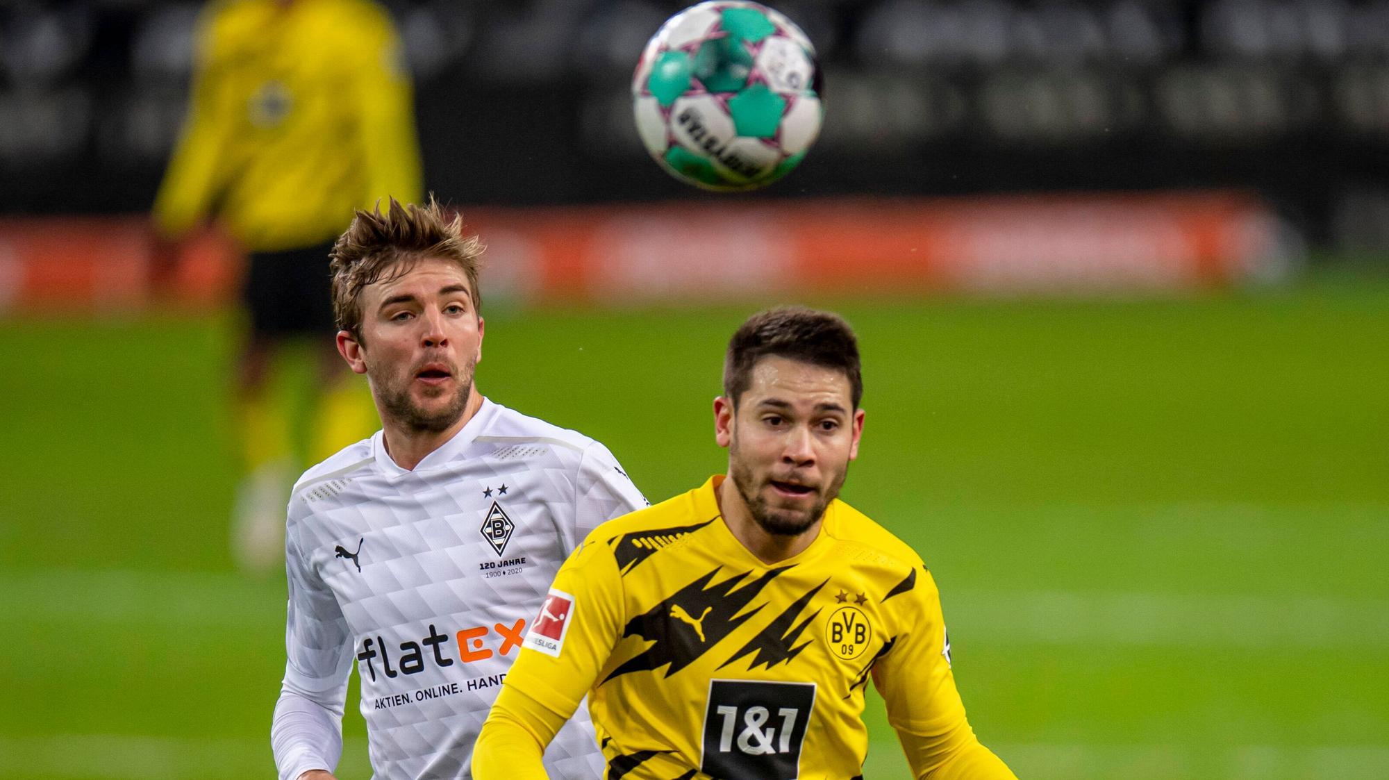 Gladbachs Mittelfeldspieler Christoph Kramer (l.) und Dortmunds Raphael Guerreiro (r.) blicken im Bundesliga-Duell am 22. Januar 2021 auf den Ball.