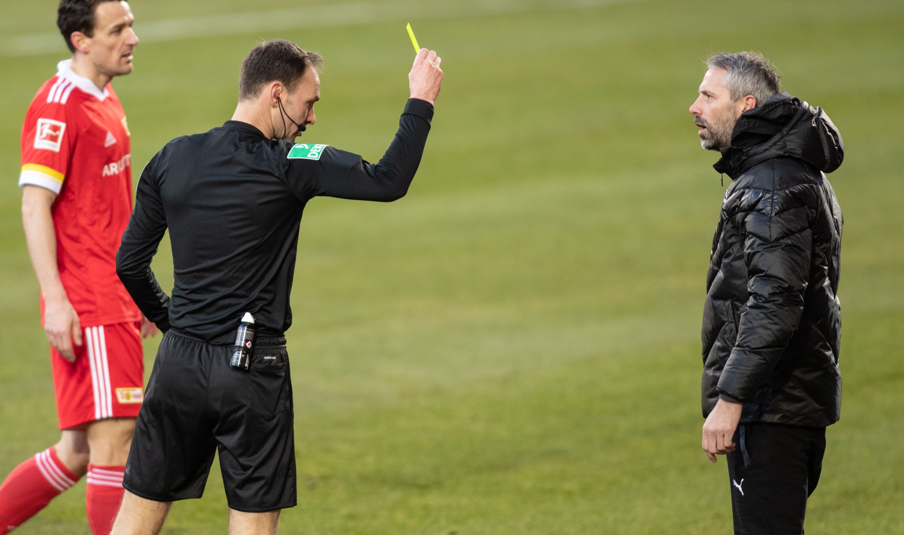 Schiedsrichter Bastian Dankert (M.) zeigt Gladbach-Trainer Marco Rose (r.) die Gelbe Karte am 30. Januar 2021.