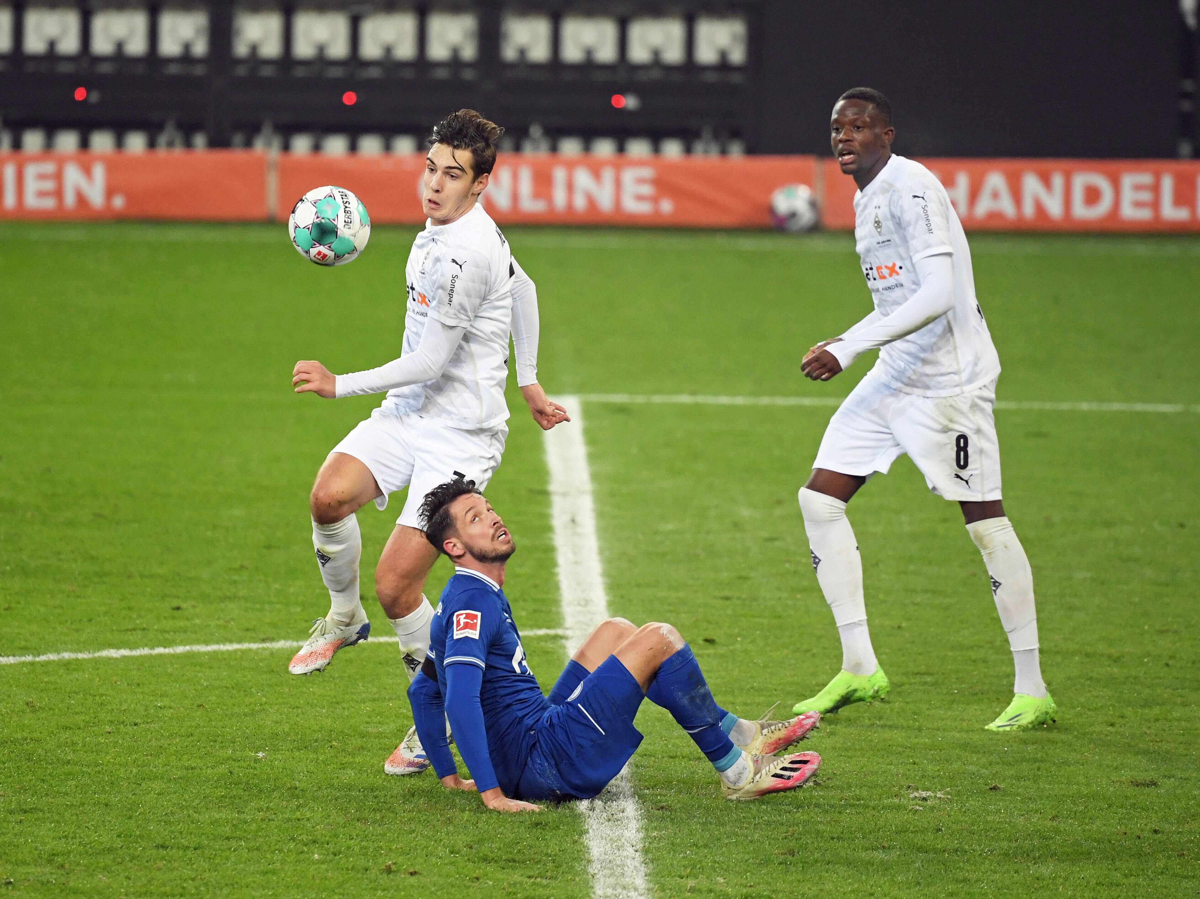 Die Gladbacher Profis Florian Neuhaus (l.) und Denis Zakaria (r.), hier am 28. November 2020 im Bundesliga-Duell gegen Schalke 04 zu sehen, schauen gebannt auf den Ball.