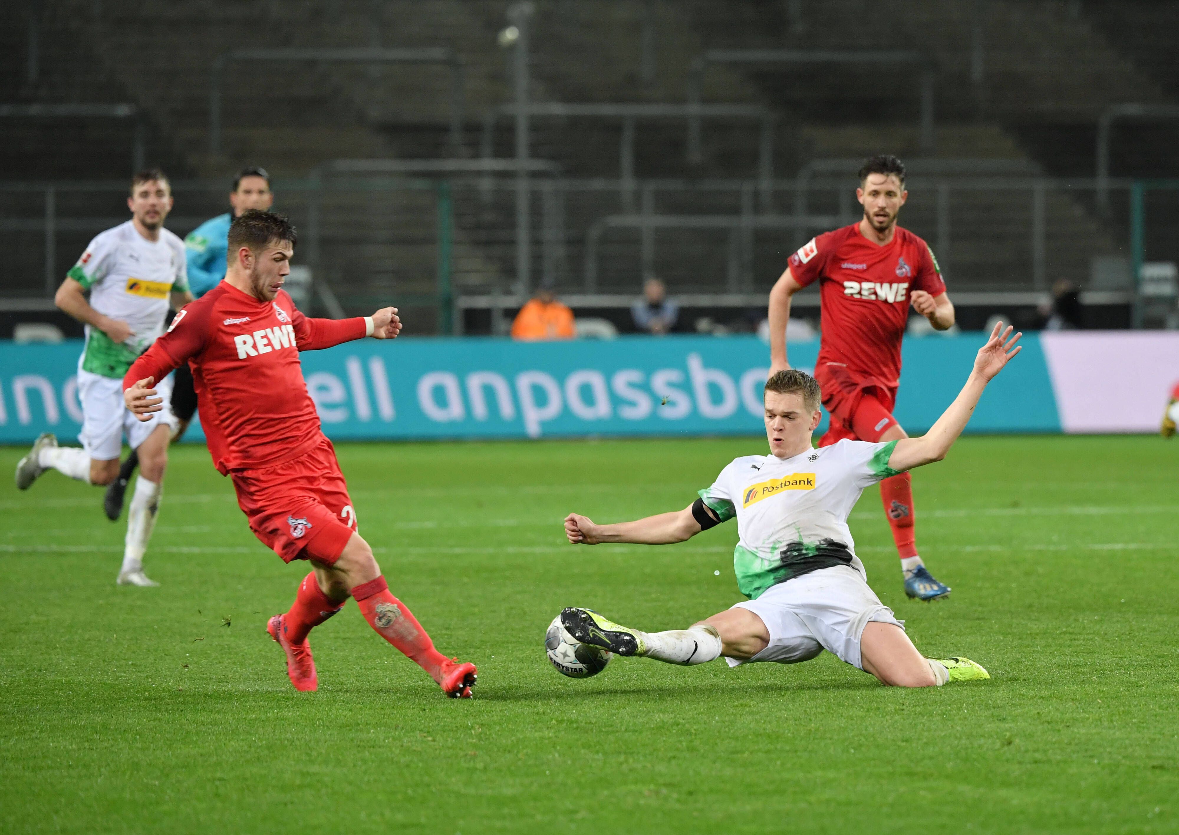 Borussias Matthias Ginter (r.) streckt sich im Rheinischen Derby im März 2020 vor Kölns Jan Thielmann (l.) nach dem Ball.