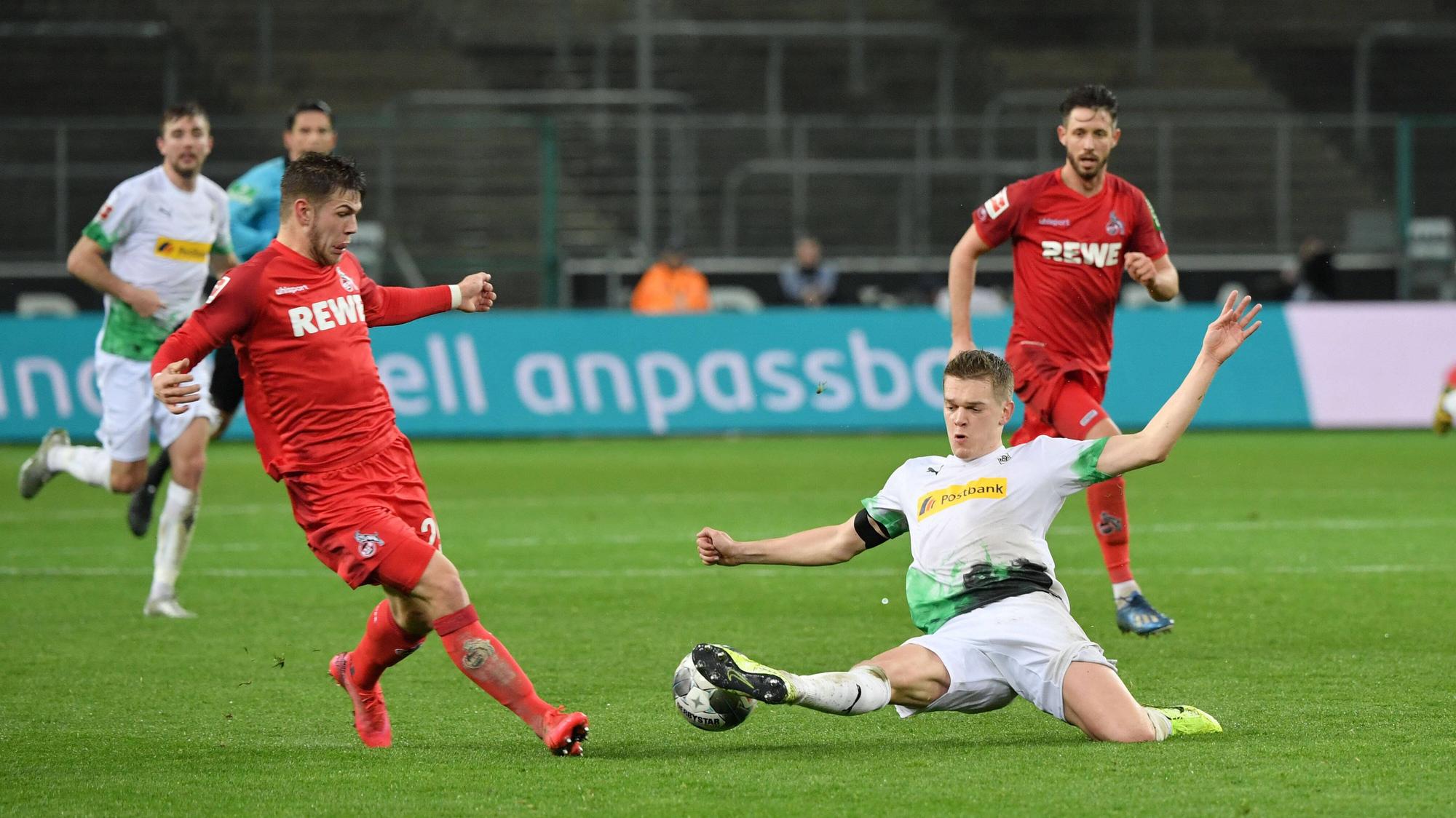 Borussias Matthias Ginter (r.) streckt sich im Rheinischen Derby im März 2020 vor Kölns Jan Thielmann (l.) nach dem Ball.