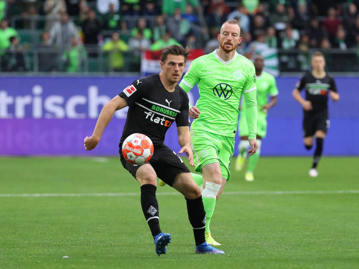 Jonas Hofmann (l.) von Borussia Mönchengladbach im Zweikampf mit Maximilian Arnold (r.) vom VfL Wolfsburg während des Bundesliga-Duells am 2. Oktober 2021 in der VW Arena. Hofmann hat den Ball vor sich.