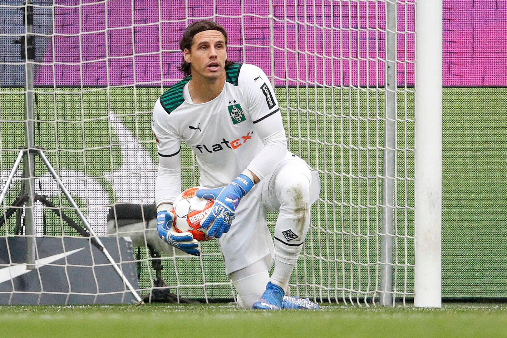 Gladbach-Schlussmann Yann Sommer hat sich beim Bundesliga-Sieg der Borussia in Wolfsburg (2. Oktober 2021) als starker Rückhalt für seine Mannschaft erwiesen. Sommer kniet auf dem Rasen und hält den Fußball fest in seinen Händen.