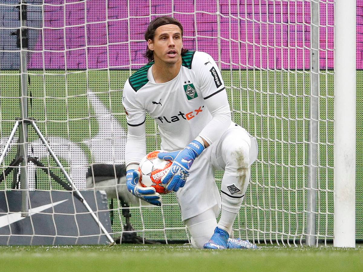 Gladbach-Schlussmann Yann Sommer hat sich beim Bundesliga-Sieg der Borussia in Wolfsburg (2. Oktober 2021) als starker Rückhalt für seine Mannschaft erwiesen. Sommer kniet auf dem Rasen und hält den Fußball fest in seinen Händen.