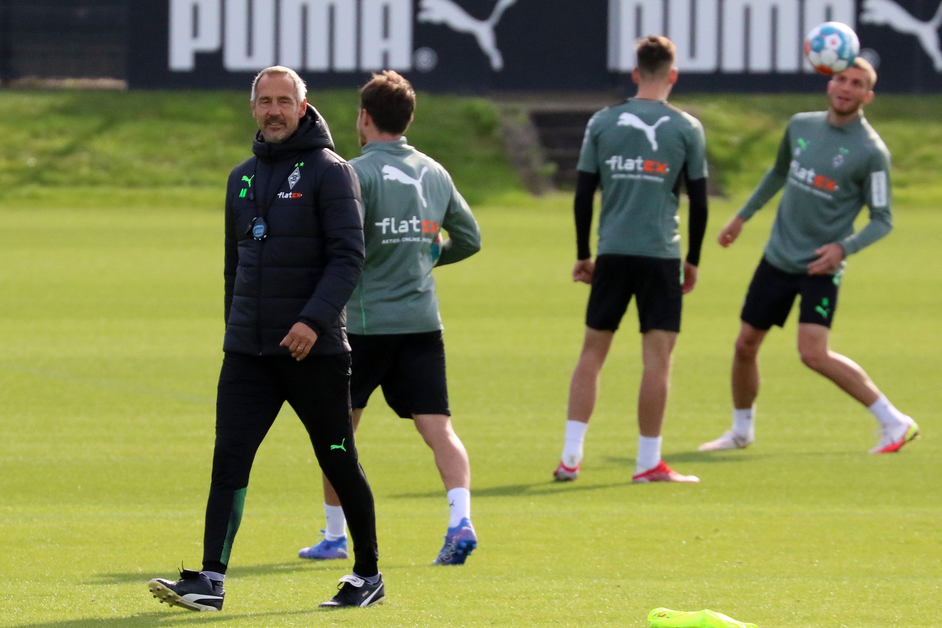 Adi Hütter, Trainer von Borussia Mönchengladbach, hier am 30. September 2021, läuft über den Trainingsplatz. Im Hintergrund trainieren drei Gladbach-Spieler-