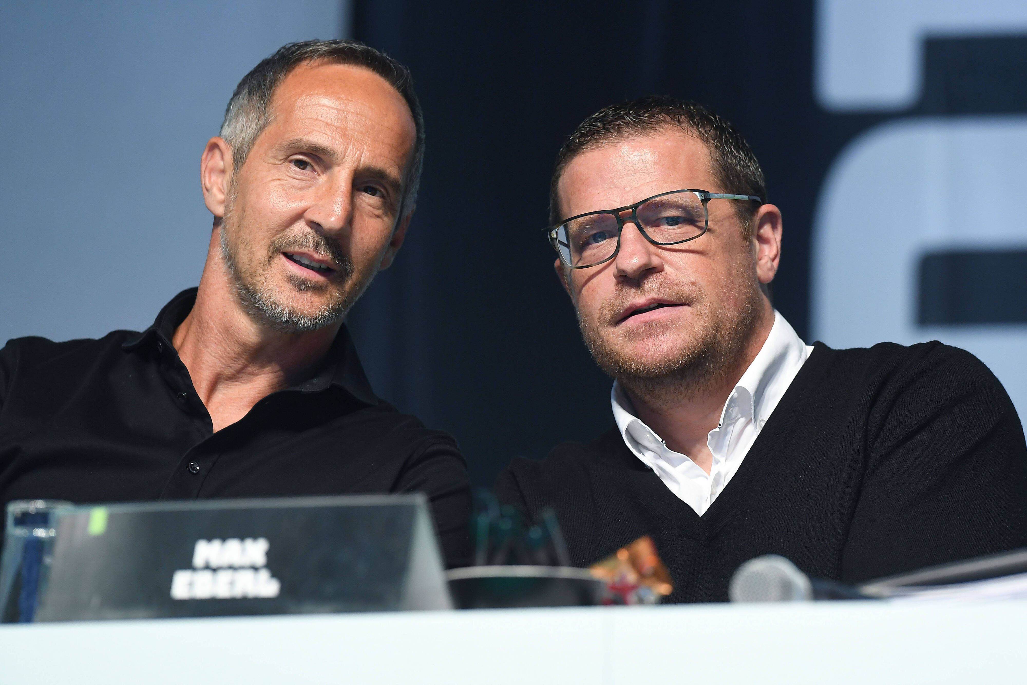 Adi Hütter (l.), Trainer von Borussia Mönchengladbach, ist gemeinsam mit dem ehemaligen Sportdirektor Max Eberl (r.) am 10. August 2021 während der Mitgliederversammlung im Borussia-Park zu sehen. Beide schauen von der Bühne herab in die Kamera des Fotografen.