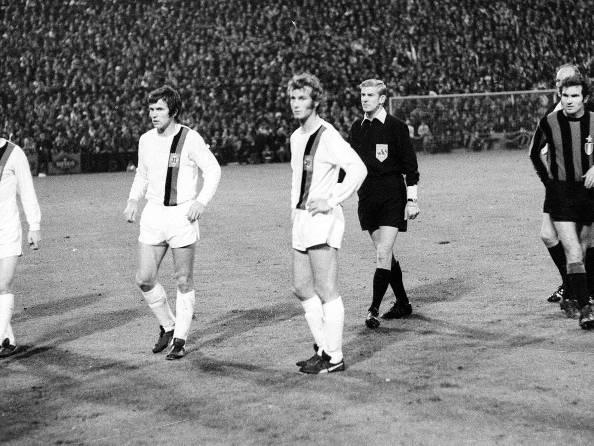 Die Gladbach-Spieler Herbert Wimmer, Jupp Heynckes und Rainer Bonhof (v.li.) verharren auf dem Rasen des Bökelbergstadions. Zuvor hatte eine Cola-Dose den Spieler Roberto Boninsegna von Inter Mailand beim Europapokal-Duell am 20. Oktober 1971 getroffen. Das Spiel endete 7:1 für Gladbach, wurde aber später von der UEFA annulliert.