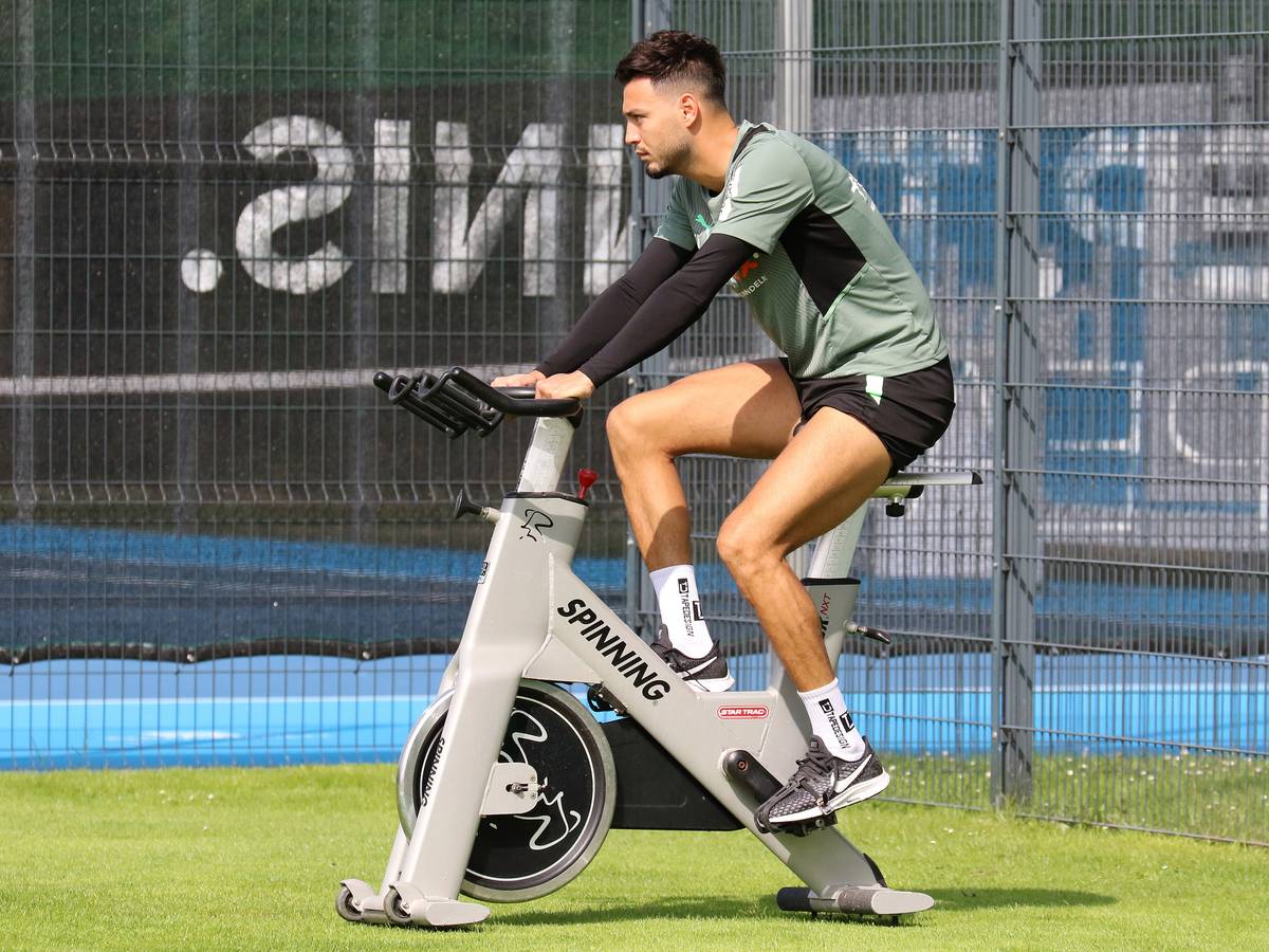 Ramy Bensebaini von Borussia Mönchengladbach sitzt am 18. Juli 2021 auf einem Spinning-Rad während des Trainingslagers in Harsewinkel. Bensebaini schaut nach vorne und radelt.
