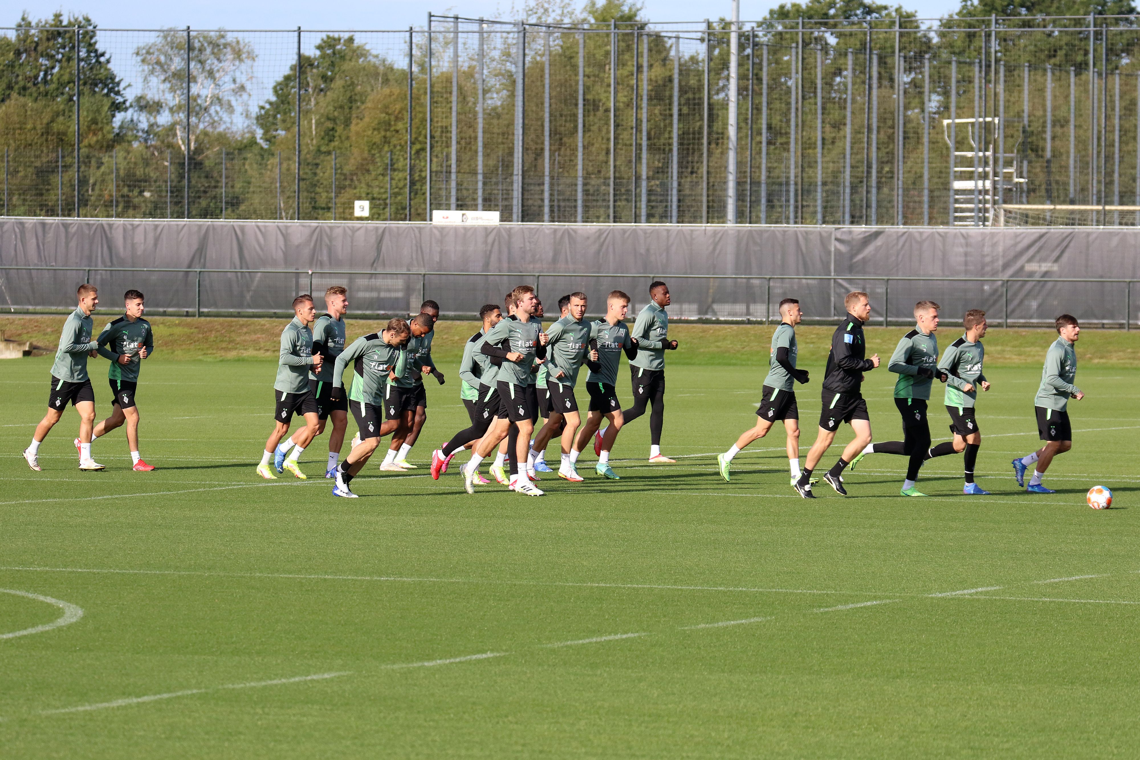 Teile der Mannschaft von Borussia Mönchengladbach laufen sich am 30. September 2021 beim Training am Borussia-Park warm.