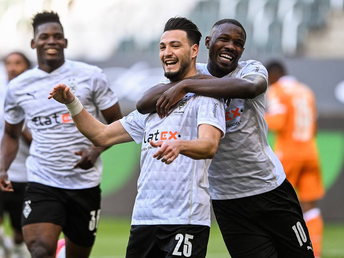 Auf Verteidiger Ramy Bensebaini (Mitte) und Stürmer Marcus Thuram muss Borussia Mönchengladbach bereits seit Wochen verzichten. Auf diesem Foto sind die beidem 25. April 2021 im Borussia-Park zu sehen. Thuram umarmt Bensebaini.