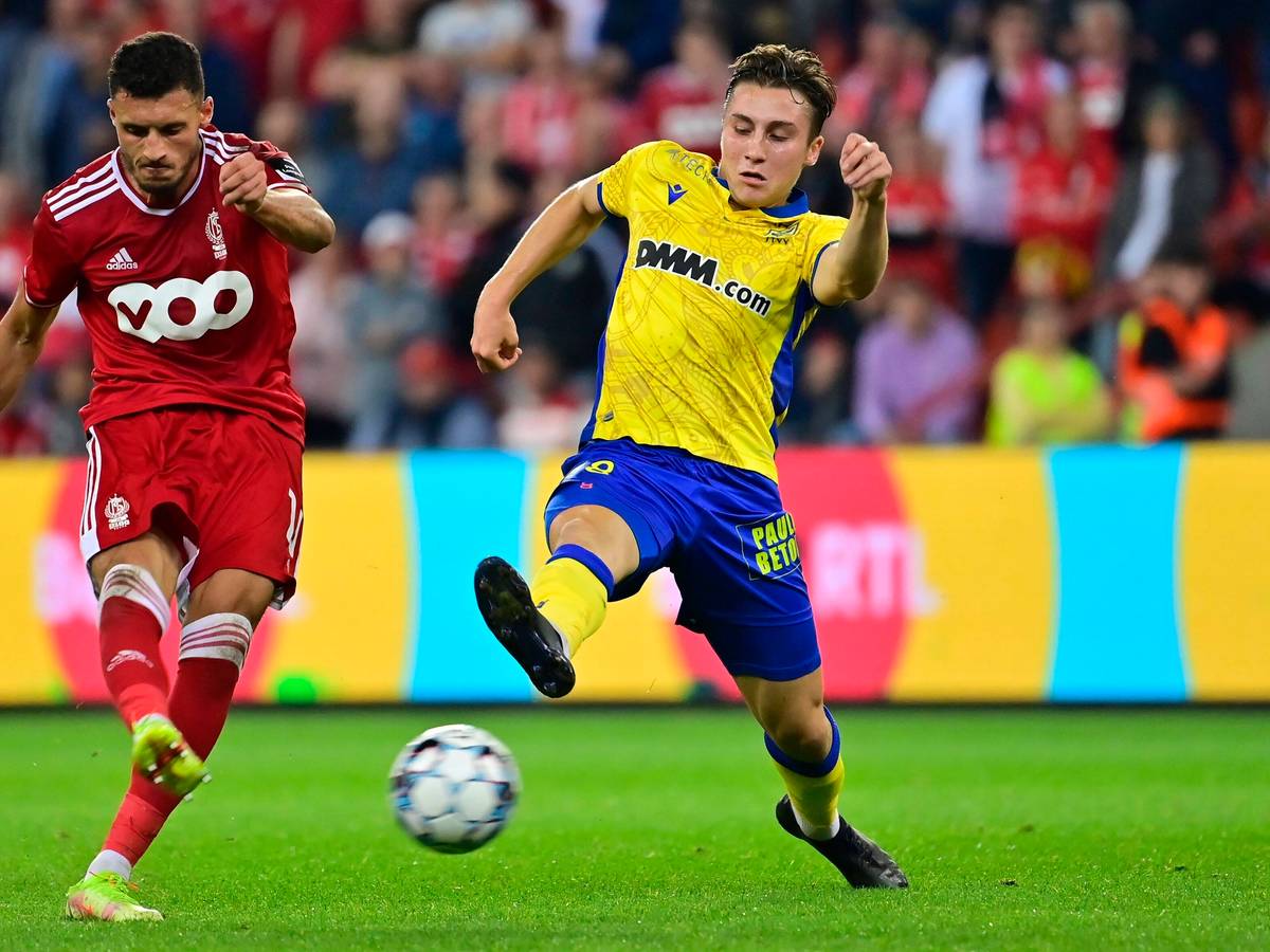 Borussia Mönchengladbach hat Rocco Reitz (r.) an den belgischen Erstligisten VV St. Truiden ausgeliehen. In dieser Szene ist der Mittelfeldspieler am 25. September 2021 in Lüttich im Duell mit Selim Amallah (l.) von Standard Lüttich zu sehen. Reitz streckt sein Bein aus und will einen Schuss blockieren.
