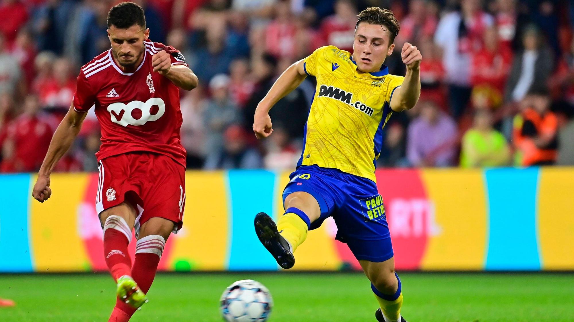 Borussia Mönchengladbach hat Rocco Reitz (r.) an den belgischen Erstligisten VV St. Truiden ausgeliehen. In dieser Szene ist der Mittelfeldspieler am 25. September 2021 in Lüttich im Duell mit Selim Amallah (l.) von Standard Lüttich zu sehen. Reitz streckt sein Bein aus und will einen Schuss blockieren.