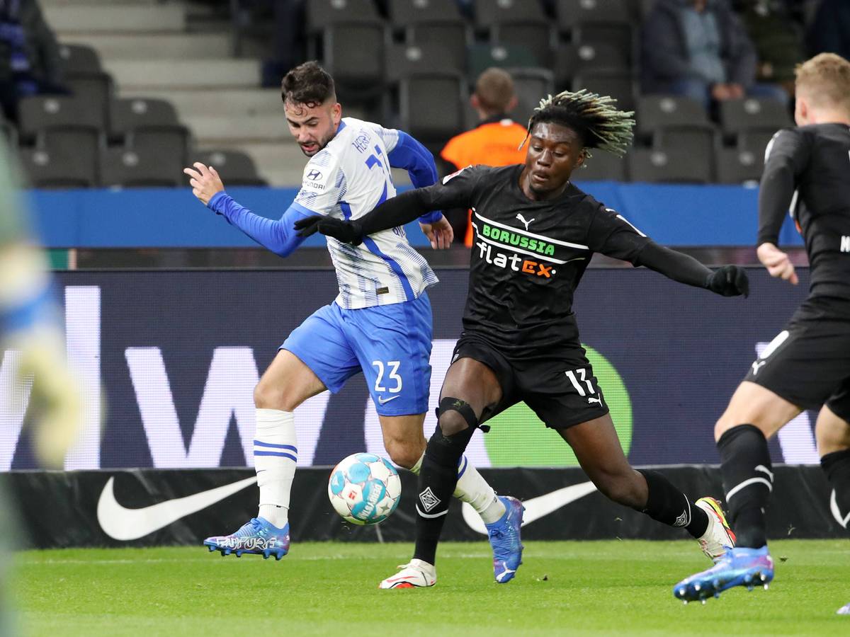 Manu Kone (M.) von Borussia Mönchengladbach im Zweikampf mit Berlins Marco Richter (l.) im Bundesliga-Topspiel am Samstag (23. Oktober 2021) im Olympiastadion. Elvedi rechts beobachtet.