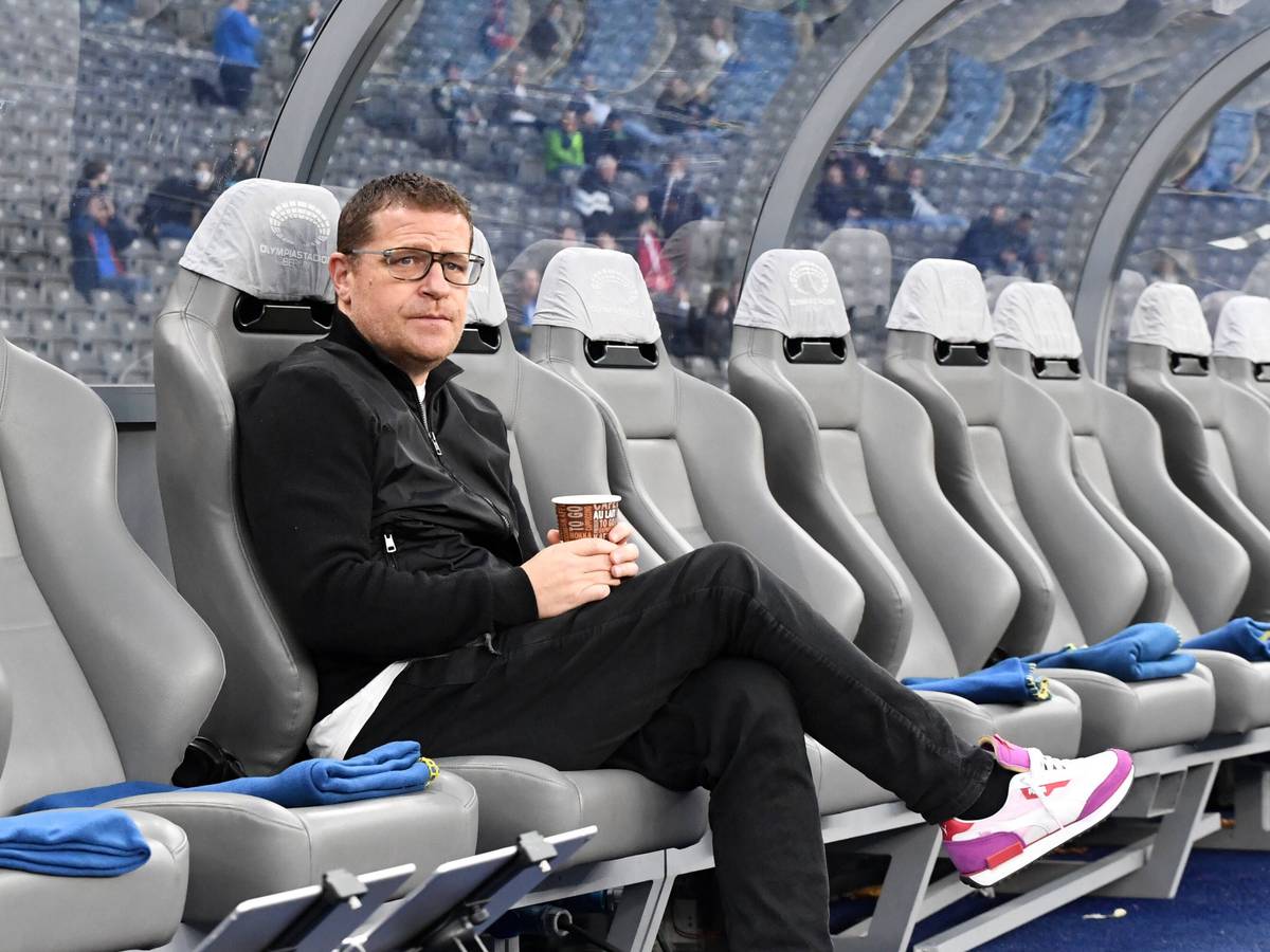 Max Eberl, Manager von Fußball-Bundesligist Borussia Mönchengladbach, sitzt vor dem Topspiel bei Hertha BSC am Samstag (23. Oktober 2021) noch ruhig auf der Ersatzbank im Olympiastadion. Eberl hält einen Getränkebecher in den Händen.