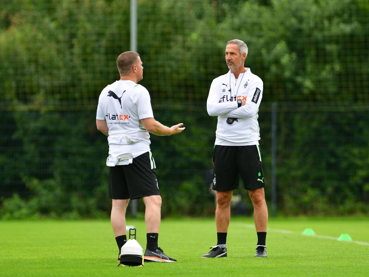 Max Eberl (l.), Manager bei Fußball-Bundesligist Borussia Mönchengladbach, unterhält sich am 21. Juli 2021 in Harsewinkel mit Cheftrainer Adi Hütter (r.). Eberl redet, Hütter hört zu.