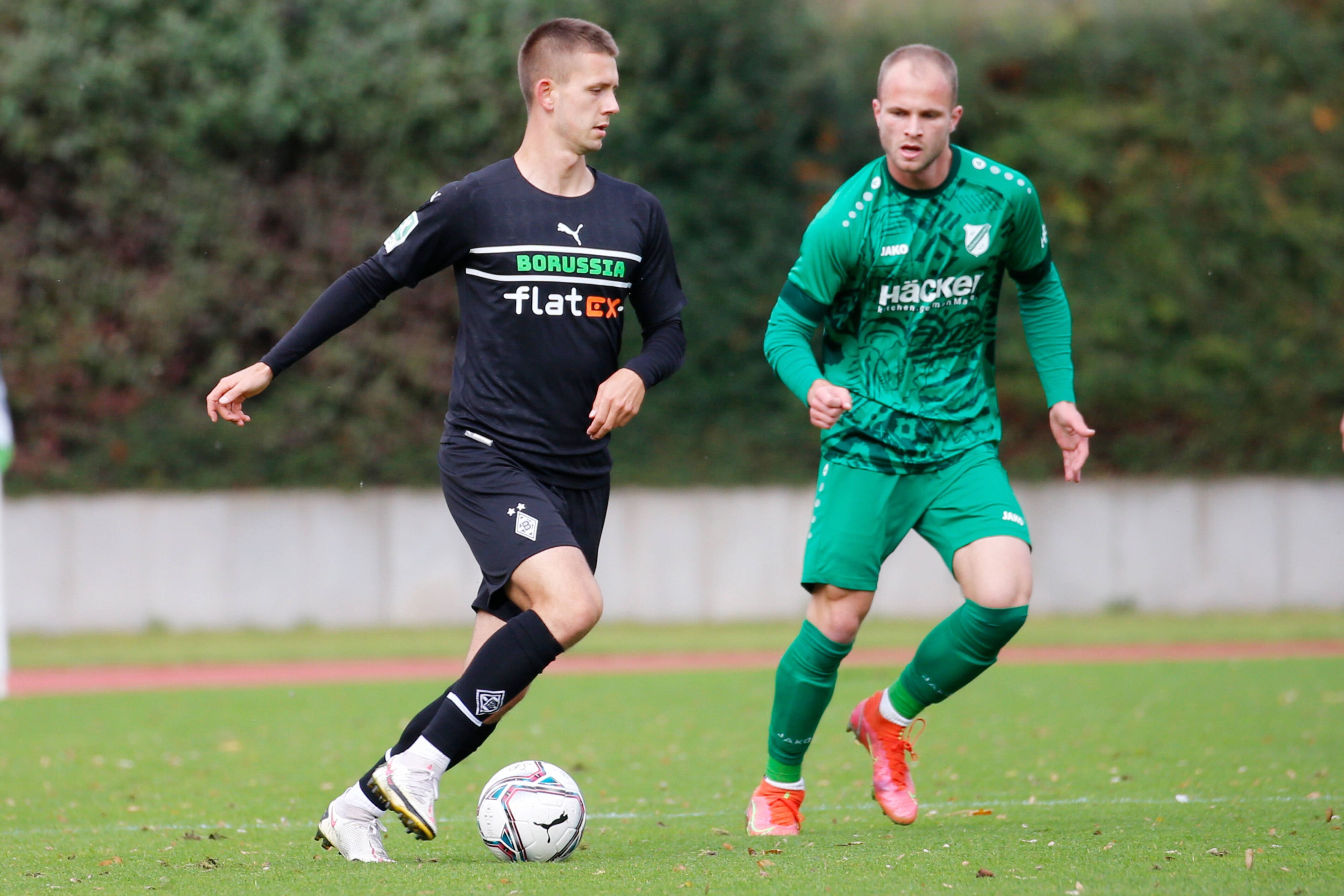 Torben Müsel (l.), Spieler der U23 von Borussia Mönchengladbach, im Regionalliga-Duell mit Patrick Kurzen (r.) von SV Rödinghausen am Samstag (23. Oktober 2021) im Rheydter Grenzlandstadion. Müsel hat den Ball am rechten Fuß.