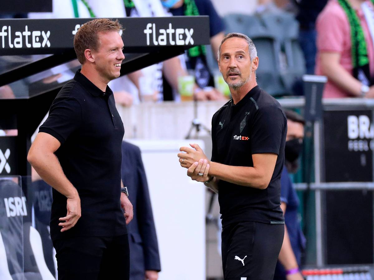 Adi Hütter (r.), Trainer von Fußball-Bundesligist Borussia Mönchengladbach, am 13. August 2021 im Borussia-Park im Gespräch mit seinem Kollegen Julian Nagelsmann (l.), der bei Bayern München unter Vertrag steht. Nagelsmann lächelt.