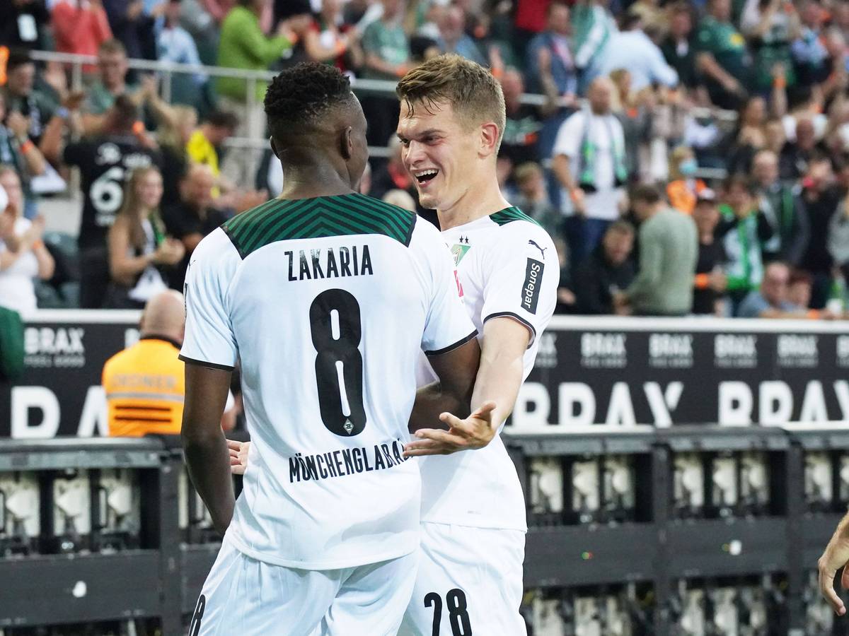 Denis Zakaria (l.) und Matthias Ginter (r.), beide noch bis Ende Juni 2022 bei Fußball-Bundesligist Borussia Mönchengladbach unter Vertrag, freuen sich gemeinsam über den Siegtreffer im Duell gegen Dortmund am 25. September 2021. Beide schauen sich an und lachen.