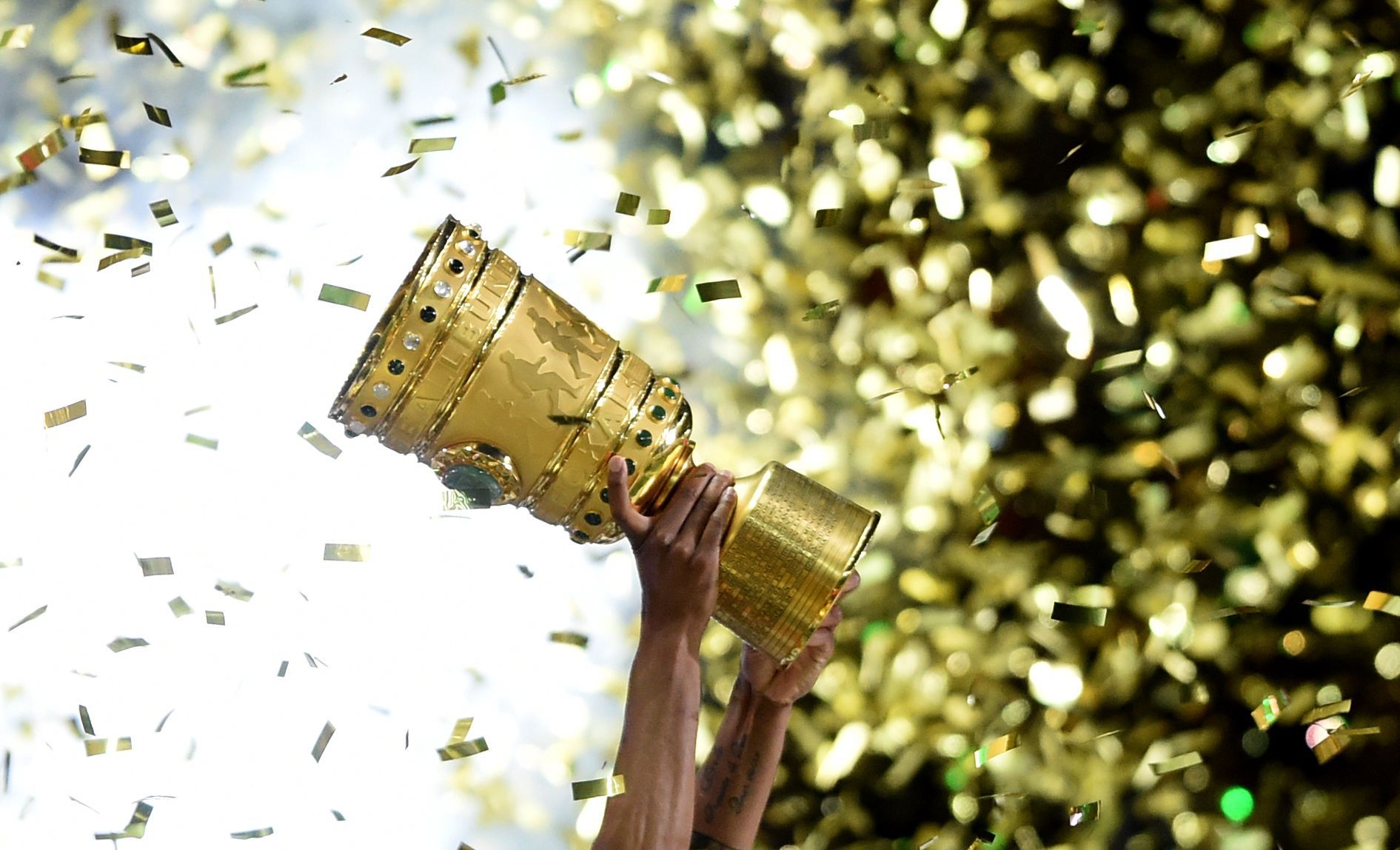 ILLUSTRATION - ARCHIV - Fußball DFB-Pokal - Finale: Borussia Dortmund - VfL Wolfsburg am 30.05.2015 im Olympiastadion in Berlin. Ein Wolfsburger hält den DFB-Pokal hoch. Am 08.08.2015 geht der DFB-Pokal in die 1. Runde. Foto: Maurizio Gambarin/dpa (zu dpa-Meldung: «Hoher Promi-Auflauf und viele Millionen: Löw sieht Chance für Hertha» vom 19.04.2016) +++ dpa-Bildfunk +++