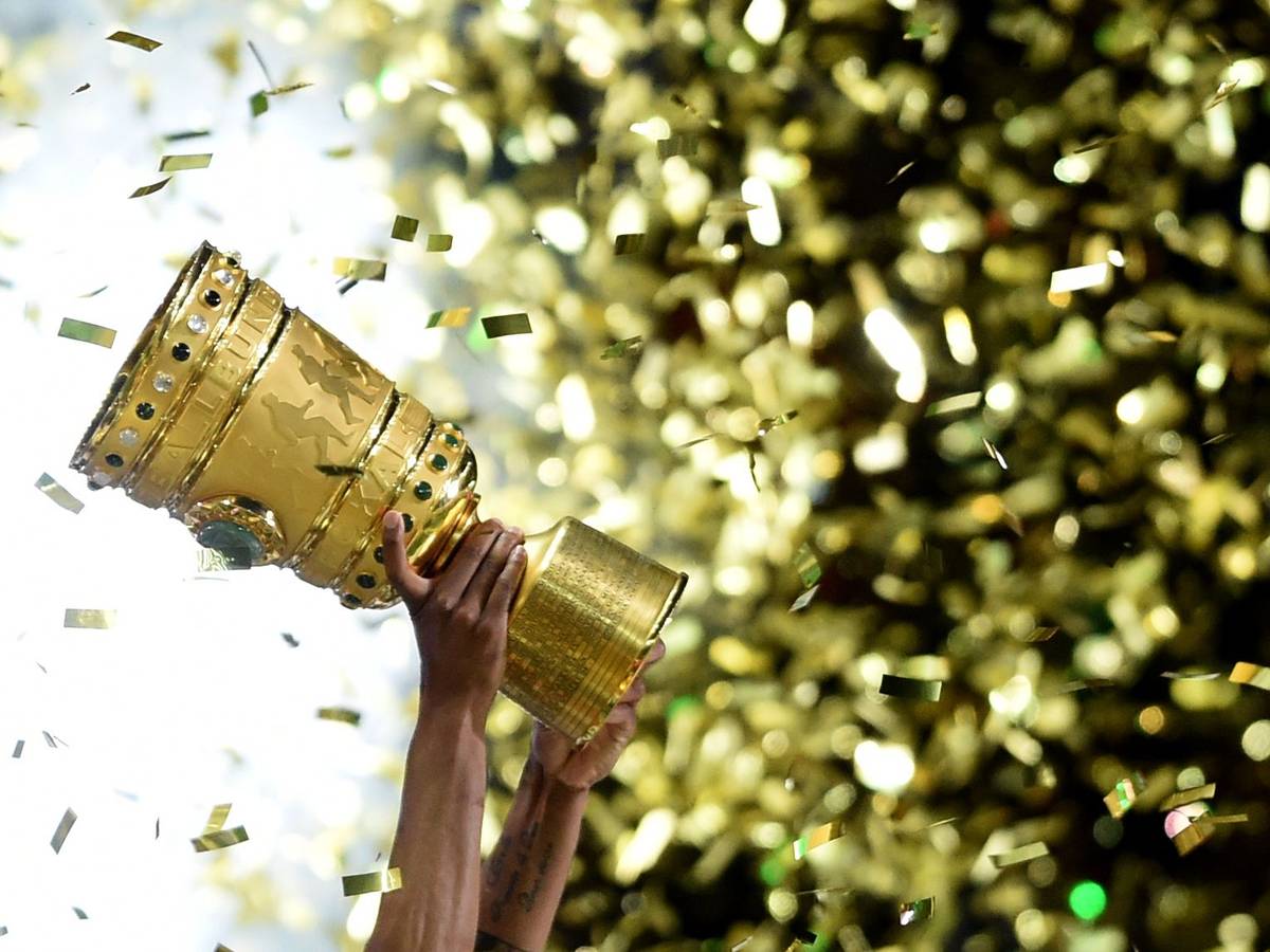 ILLUSTRATION - ARCHIV - Fußball DFB-Pokal - Finale: Borussia Dortmund - VfL Wolfsburg am 30.05.2015 im Olympiastadion in Berlin. Ein Wolfsburger hält den DFB-Pokal hoch. Am 08.08.2015 geht der DFB-Pokal in die 1. Runde. Foto: Maurizio Gambarin/dpa (zu dpa-Meldung: «Hoher Promi-Auflauf und viele Millionen: Löw sieht Chance für Hertha» vom 19.04.2016) +++ dpa-Bildfunk +++