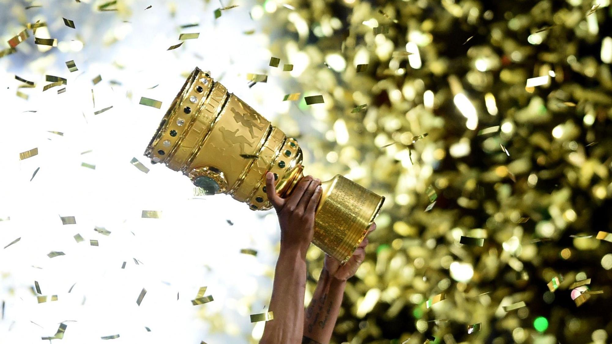 ILLUSTRATION - ARCHIV - Fußball DFB-Pokal - Finale: Borussia Dortmund - VfL Wolfsburg am 30.05.2015 im Olympiastadion in Berlin. Ein Wolfsburger hält den DFB-Pokal hoch. Am 08.08.2015 geht der DFB-Pokal in die 1. Runde. Foto: Maurizio Gambarin/dpa (zu dpa-Meldung: «Hoher Promi-Auflauf und viele Millionen: Löw sieht Chance für Hertha» vom 19.04.2016) +++ dpa-Bildfunk +++
