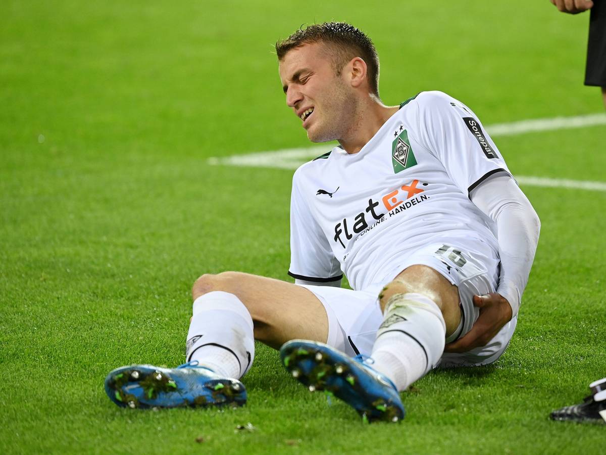 Jordan Beyer von Borussia Mönchengladbach, hier am 27. Oktober 2021, liegt auf dem Boden und hält sich den hinteren Oberschenkel mit schmerzverzerrtem Gesicht.