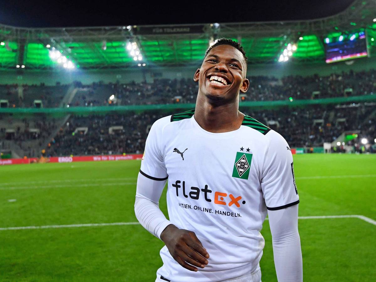 Gladbach-Stürmer Breel Embolo lacht auf dem Spielfeld im Borussia-Park. Der Schweizer Nationalspieler ist nach dem DFB-Pokalsieg von Borussia Mönchengladbach gegen Bayern München am 27. Oktober 2021 sichtlich glücklich und zufrieden.