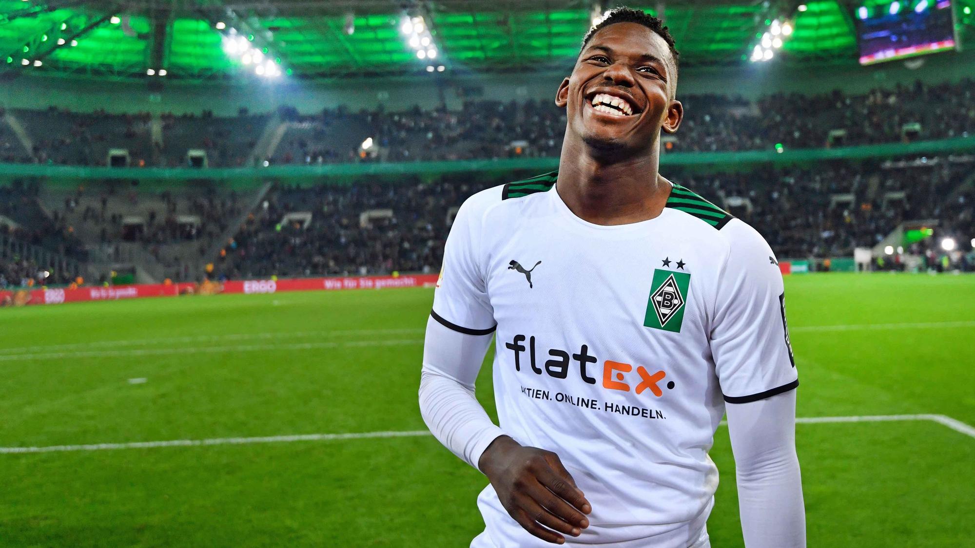 Gladbach-Stürmer Breel Embolo lacht auf dem Spielfeld im Borussia-Park. Der Schweizer Nationalspieler ist nach dem DFB-Pokalsieg von Borussia Mönchengladbach gegen Bayern München am 27. Oktober 2021 sichtlich glücklich und zufrieden.