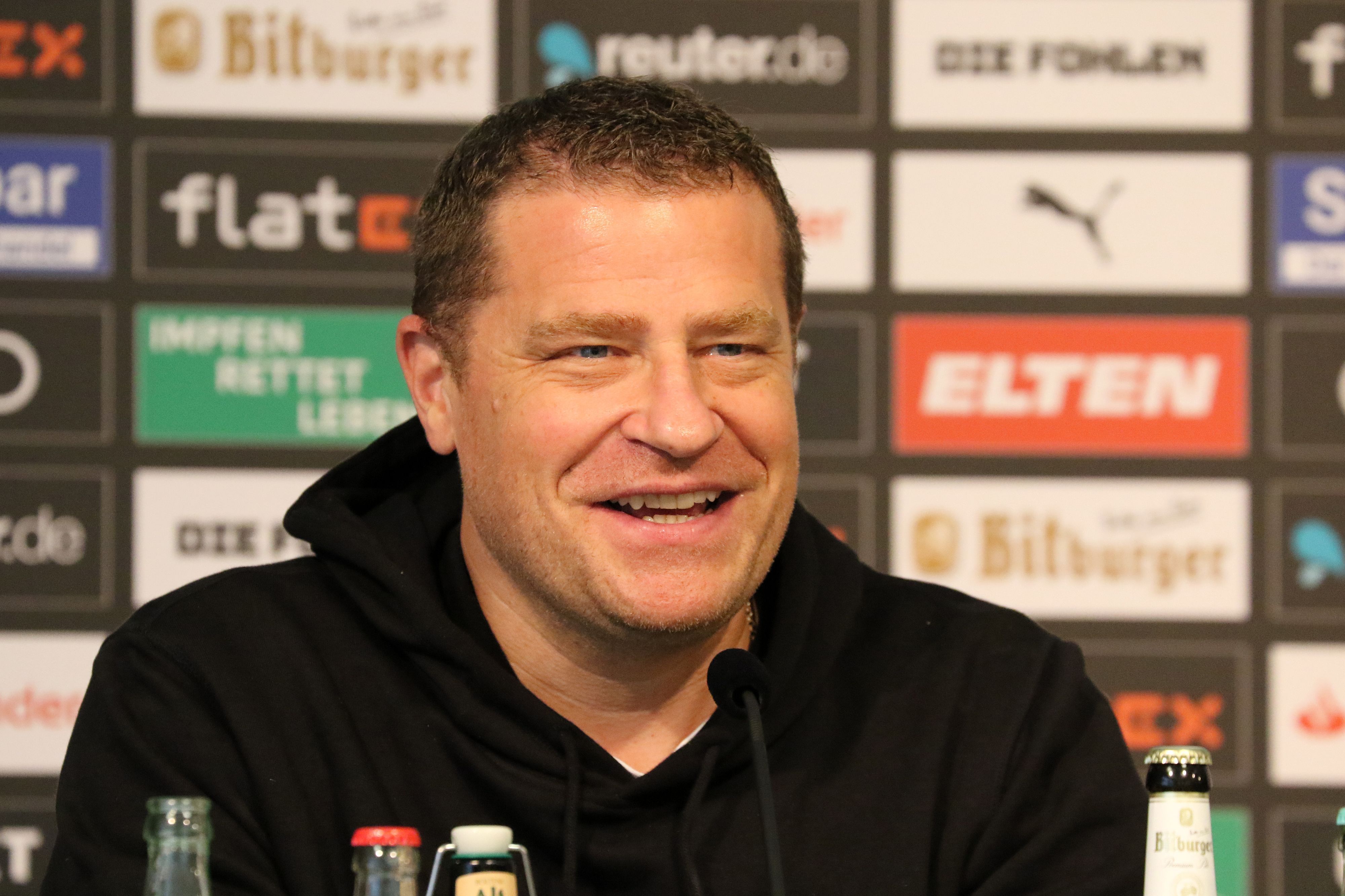 Gladbachs Sportdirektor Max Eberl bei einer Pressekonferenz am 21.10.2021 im Borussia-Park lachend.
