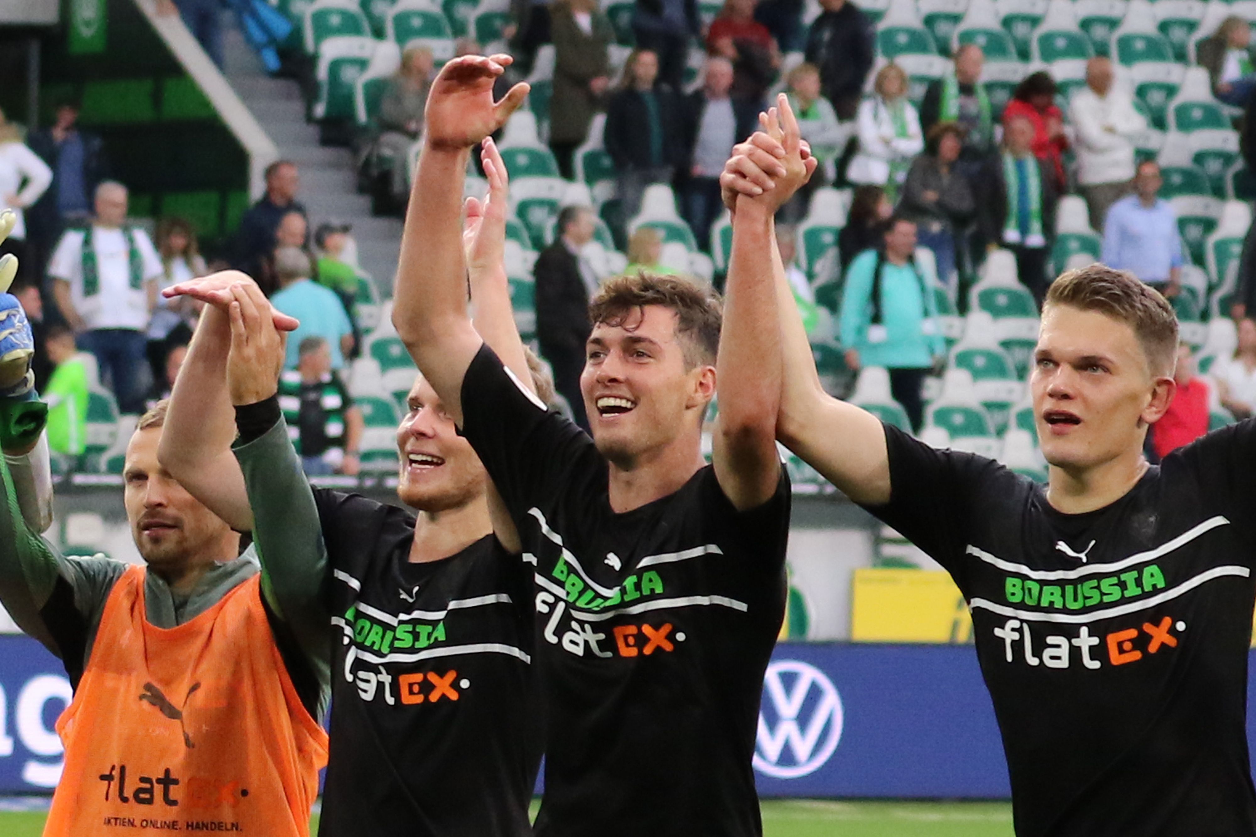 Joe Scally (Mitte) von Borussia Mönchengladbach, mit seinen Teamkollegen Nico Elvedi (l.) und Matthias Ginter (r.) beim Feiern mit den Fans nach der Partie beim VfL Wolfsburg am 2. Oktober 2021.