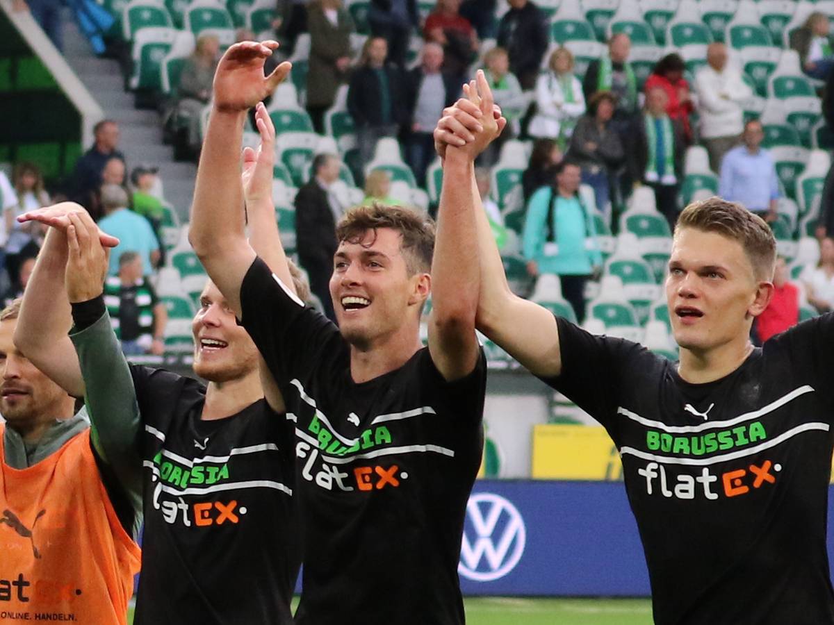 Joe Scally (Mitte) von Borussia Mönchengladbach, mit seinen Teamkollegen Nico Elvedi (l.) und Matthias Ginter (r.) beim Feiern mit den Fans nach der Partie beim VfL Wolfsburg am 2. Oktober 2021.