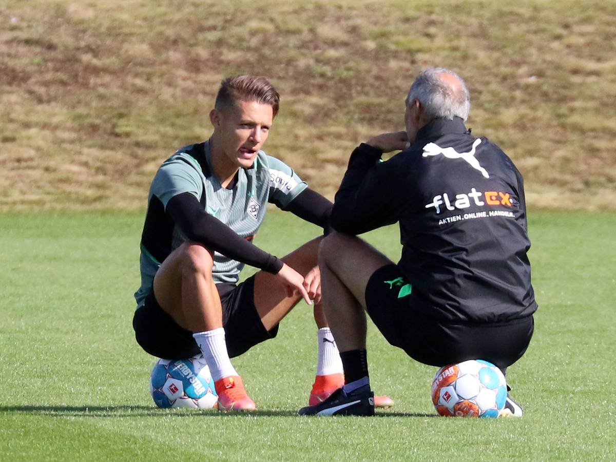 Hannes Wolf (l.) im Gespräch mit Adi Hütter (r.) von Borussia Mönchengladbach, beide sitzen auf Fußbällen auf dem Trainingsgelände am 23. September 2021.