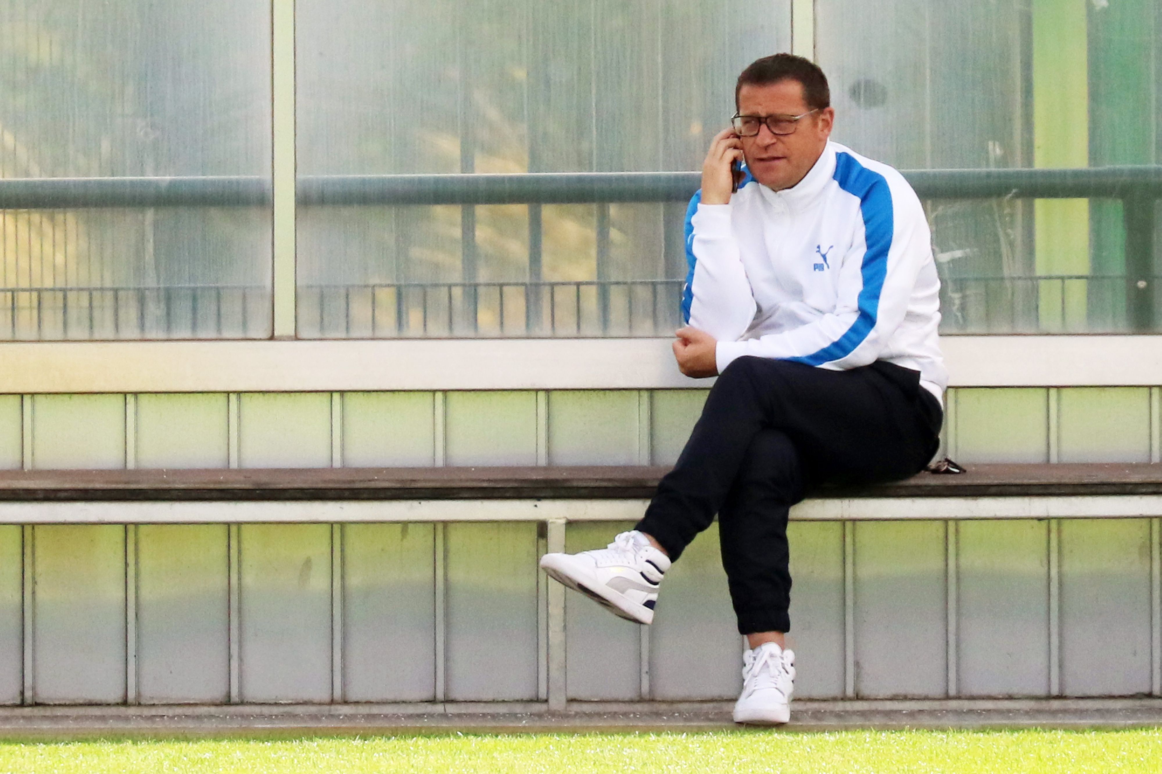 Max Eberl, Manager von Fußball-Bundesligist Borussia Mönchengladbach. Auf diesem Foto ist der 48-Jährige am 6. Juli 2021 zu sehen. Eberl sitzt auf einer Auswechselbank und telefoniert.