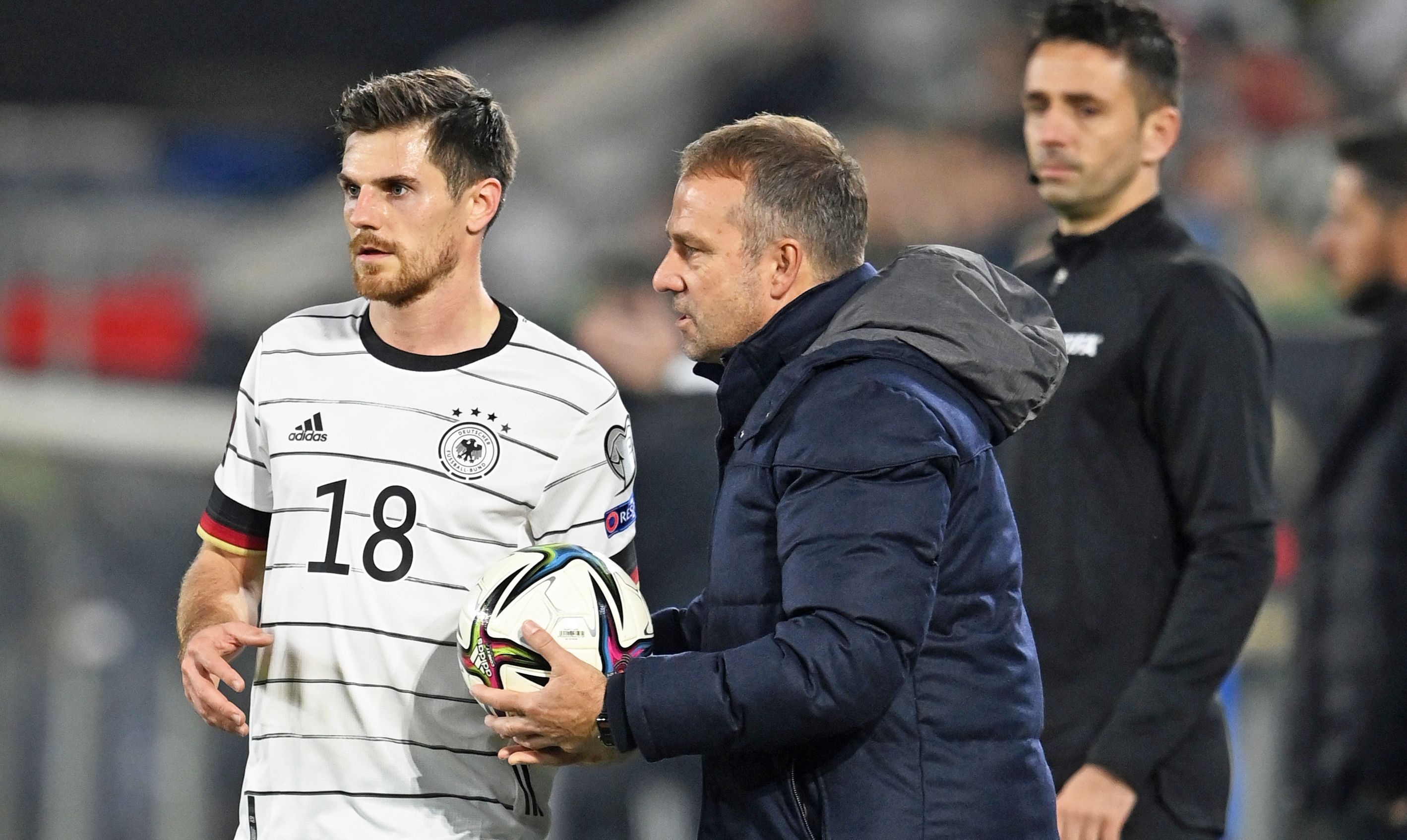 Jonas Hofmann von Borussia Mönchengladbach (l.) im Trikot der Deutschen Nationalmannschaft mit Bundestrainer Hansi Flick. Das Bild stammt vom Länderspiel Deutschland gegen Liechtenstein am 11. November 2021 in Wolfsburg. Hofmann hält den Ball zum Einwurf in der Hand, Flick gibt ihm Anweisungen.