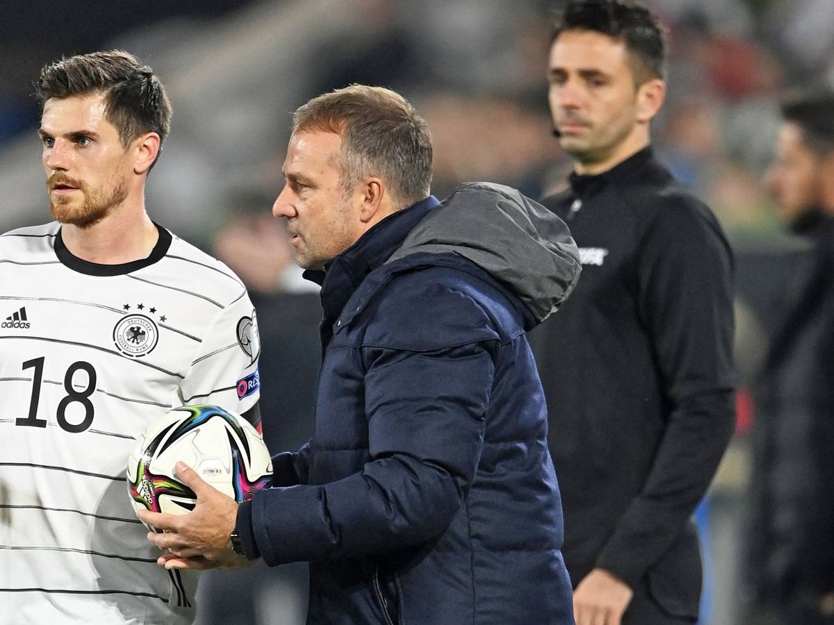 Nationalspieler Jonas Hofmann (l.) von Borussia Mönchengladbach gemeinsam mit Bundestrainer Hansi Flick (M.). Dieses Foto stammt vom 11. November 2021. Flick hält einen Ball in den Händen.