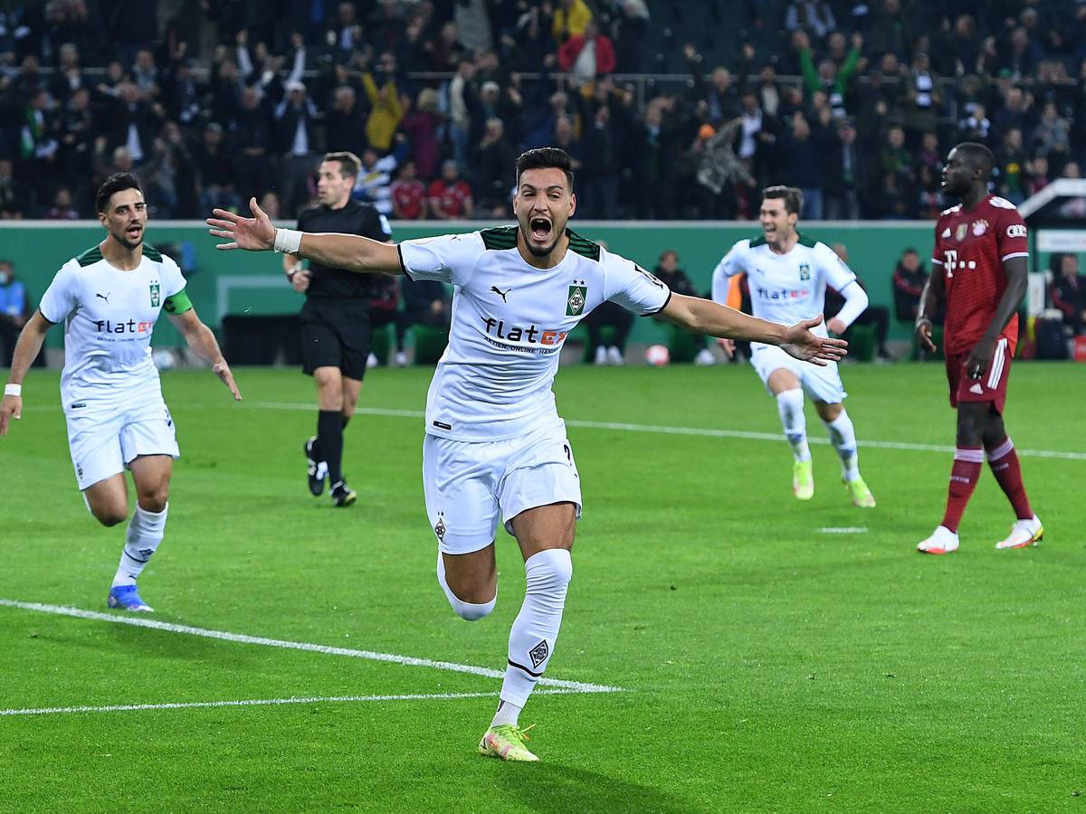 Ramy Bensebaini (M.) jubelt über einenTreffer für Borussia Mönchengladbach im DFB-Pokal-Spiel gegen Bayern München am 27. Oktober 2021 im Borussia-Park. Im Hintergrund jubeln auch Stindl und Scally.