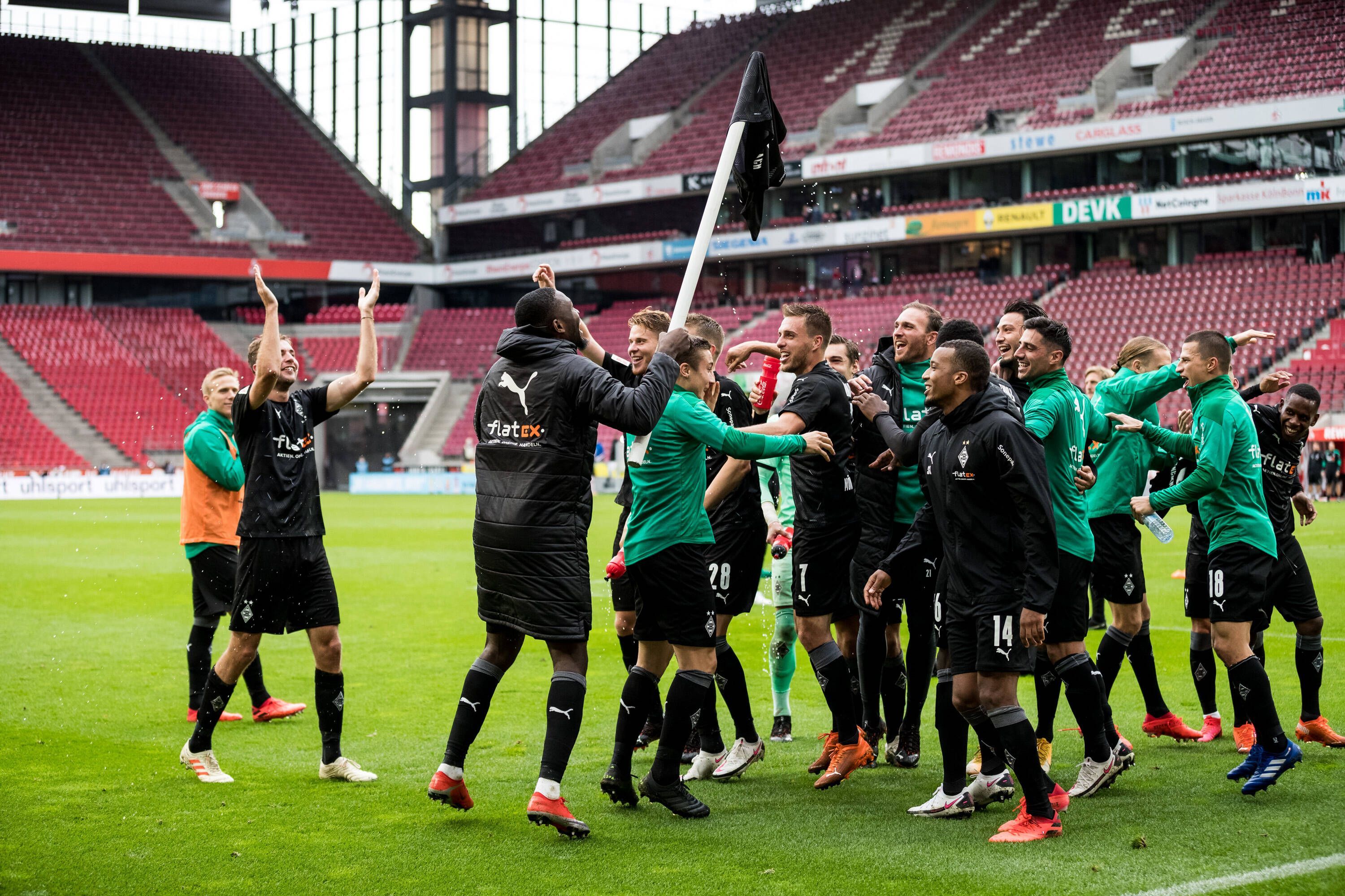 Die Spieler von Fußball-Bundesligist Borussia Mönchengladbach feiern am 3. Oktober 2020 den Auswärtssieg beim Rheinland-Rivalen 1. FC Köln. Marcus Thuram hat ein Borussia-Trikot auf eine Eckfahne gestülpt.