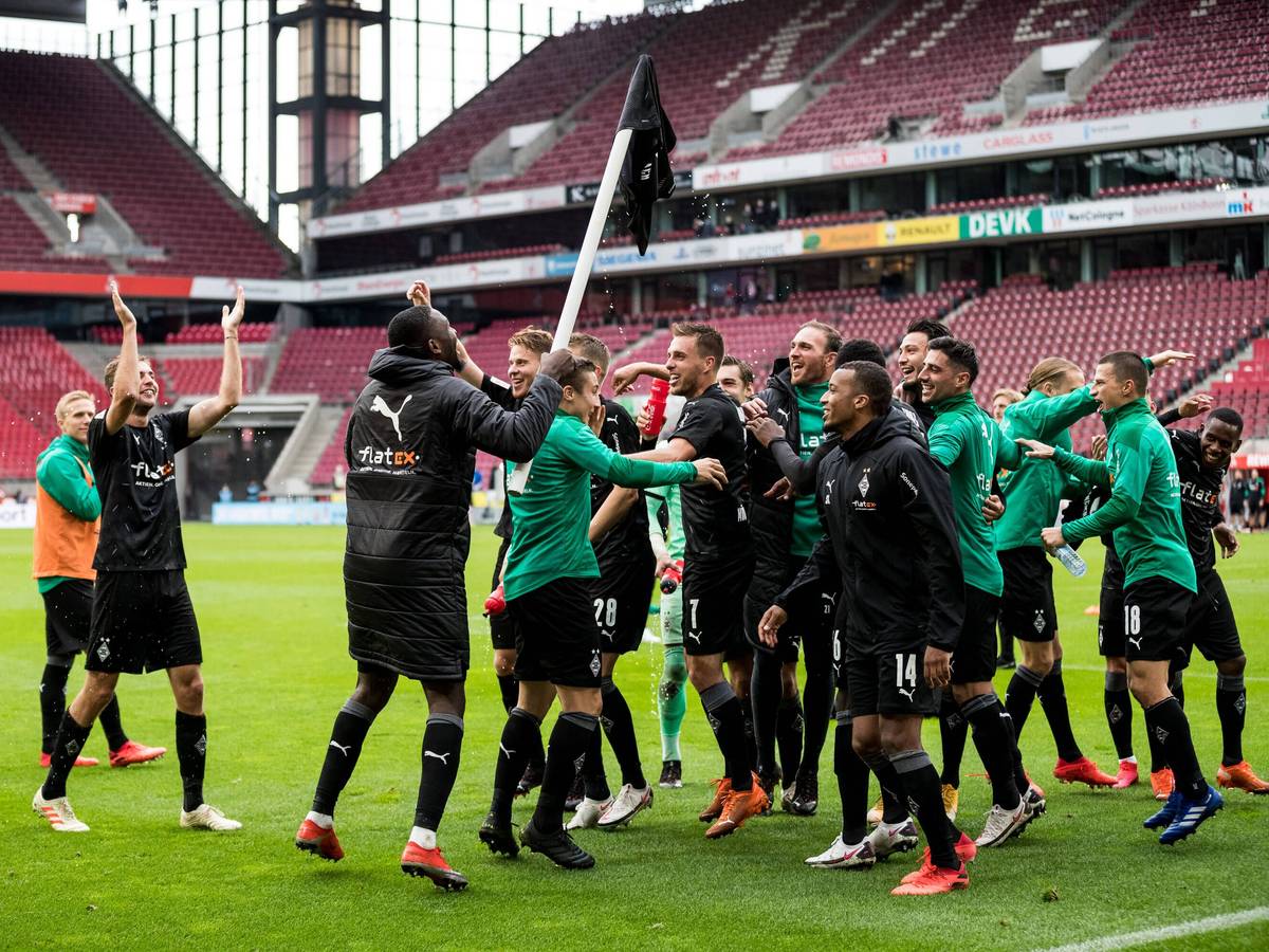 Die Spieler von Fußball-Bundesligist Borussia Mönchengladbach feiern am 3. Oktober 2020 den Auswärtssieg beim Rheinland-Rivalen 1. FC Köln. Marcus Thuram hat ein Borussia-Trikot auf eine Eckfahne gestülpt.