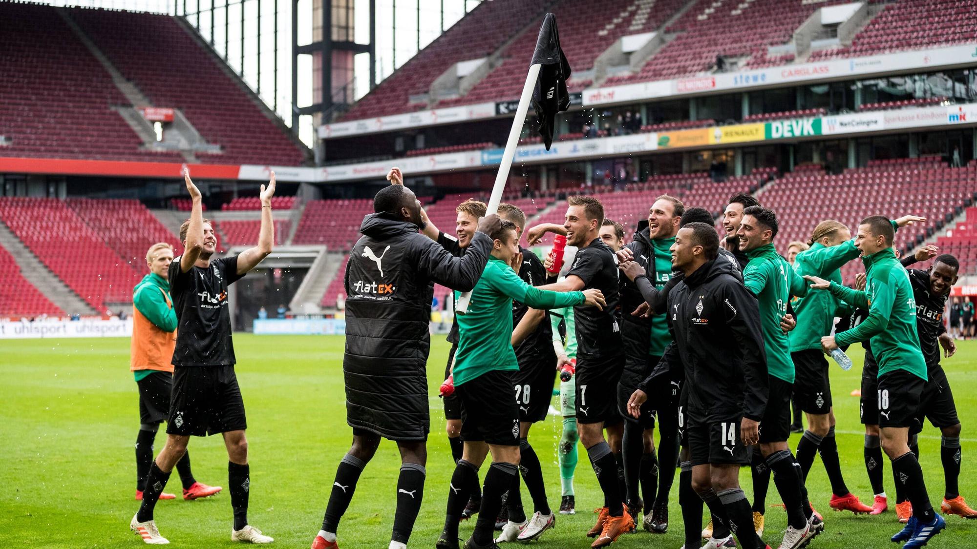 Die Spieler von Fußball-Bundesligist Borussia Mönchengladbach feiern am 3. Oktober 2020 den Auswärtssieg beim Rheinland-Rivalen 1. FC Köln. Marcus Thuram hat ein Borussia-Trikot auf eine Eckfahne gestülpt.