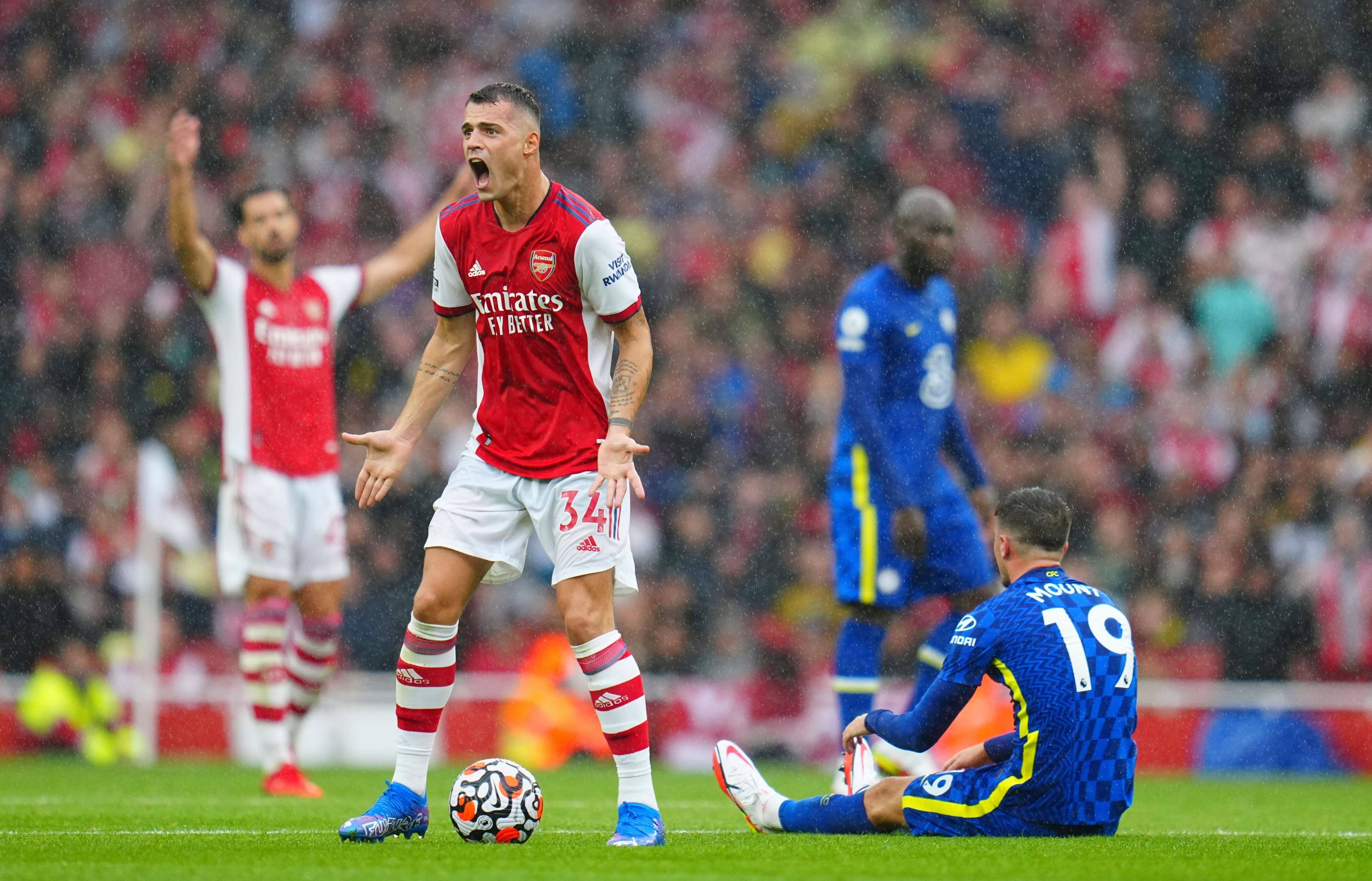 Granit Xhaka (l.), ehemaliger Kapitän von Fußball-Bundesligist Borussia Mönchengladbach, im Trikot von Arsenal London am 22. August 2021 im Premier-League-Duell gegen den FC Chelsea. Xhaka brüllt seinen Unmut heraus und gestikuliert.