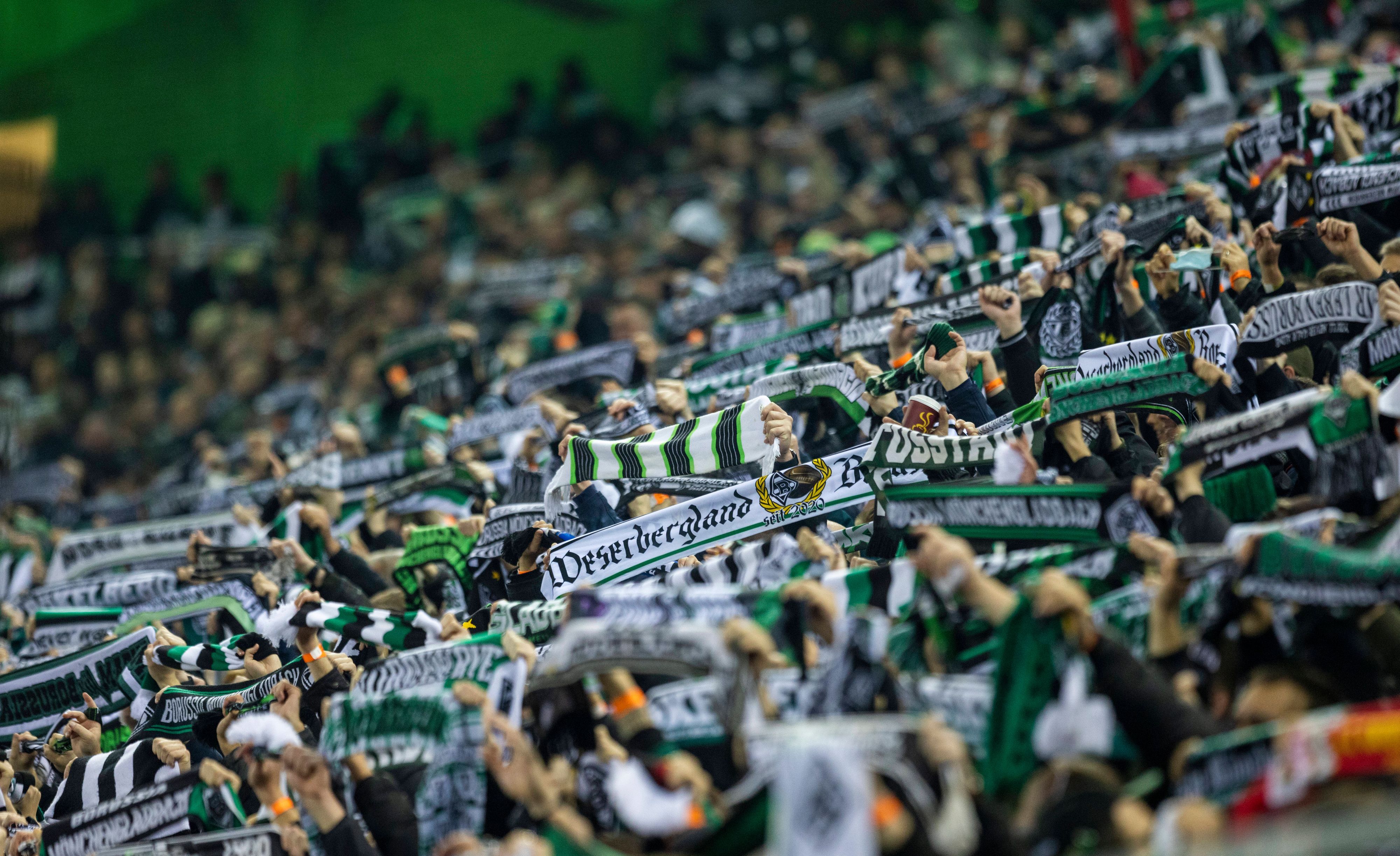 Fans von Fußball-Bundesligist Borussia Mönchengladbach am 20. November 2021 in der Nordkurve im Borussia-Park. Sie halten ihre Schals in die Höhe.